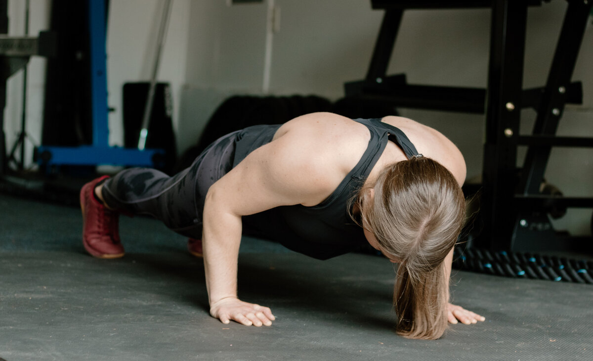 woman doing a plank on gym floor