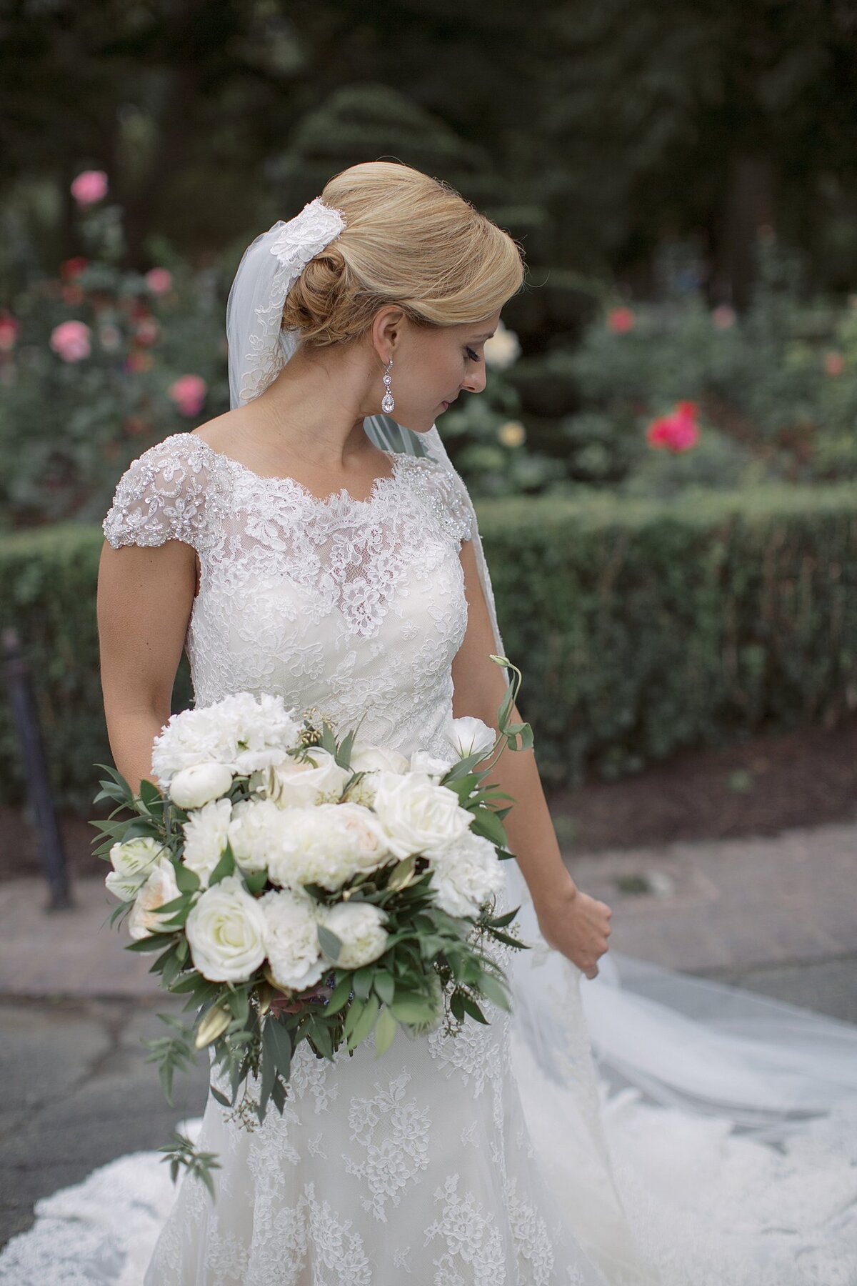 Bride adjusts veil in Boston Public Garden.