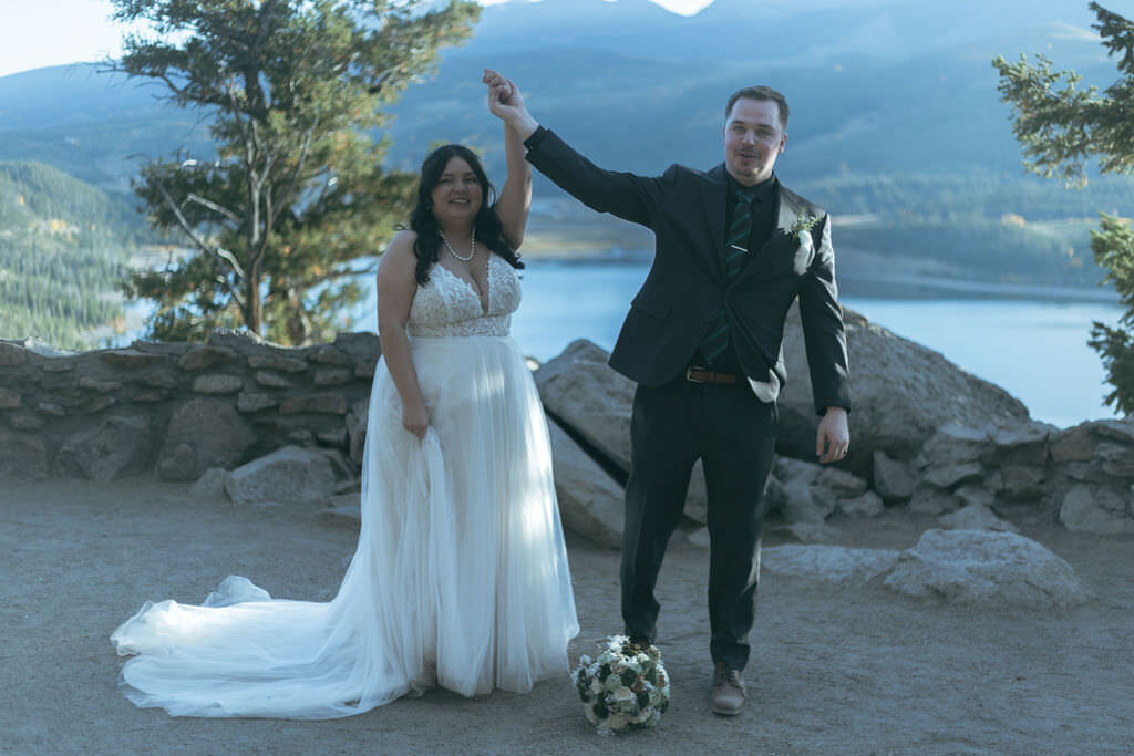 A person holding their partner's hand up after their wedding ceremony.