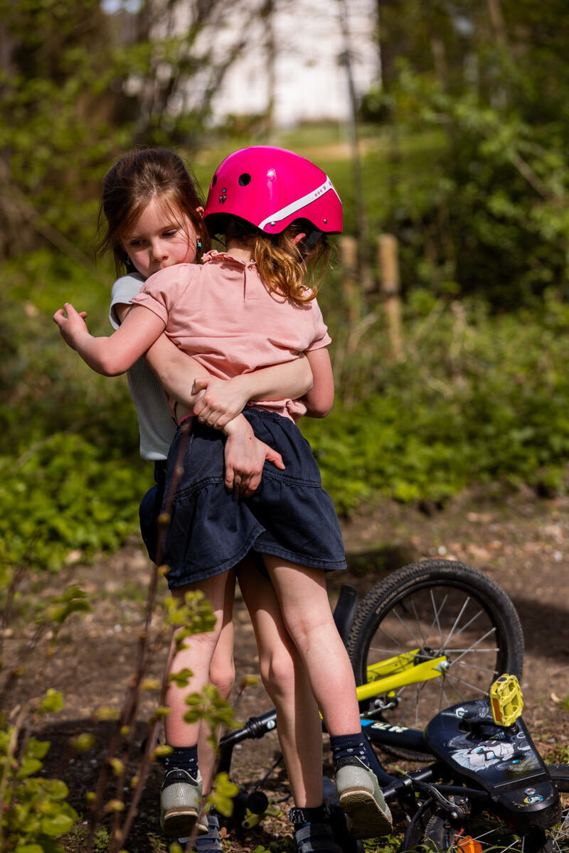 meisje helpt zusje na vallen met fiets