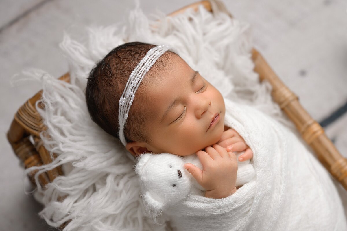 Newborn portrait in white color scheme posed in West Palm Beach newborn studio.