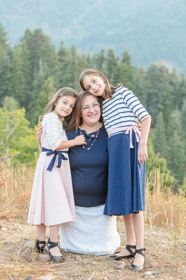 The two woodruMelissa's two daughters hugging her at Snow Basin in the fall