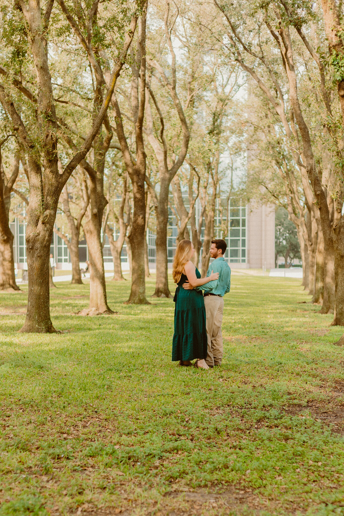 Anthony proposing to his partner in front of the iconic waterfall wall at Gerald D. Hines Waterwall Park in Houston, Texas. The couple shares a romantic moment surrounded by the cascading water and lush greenery.