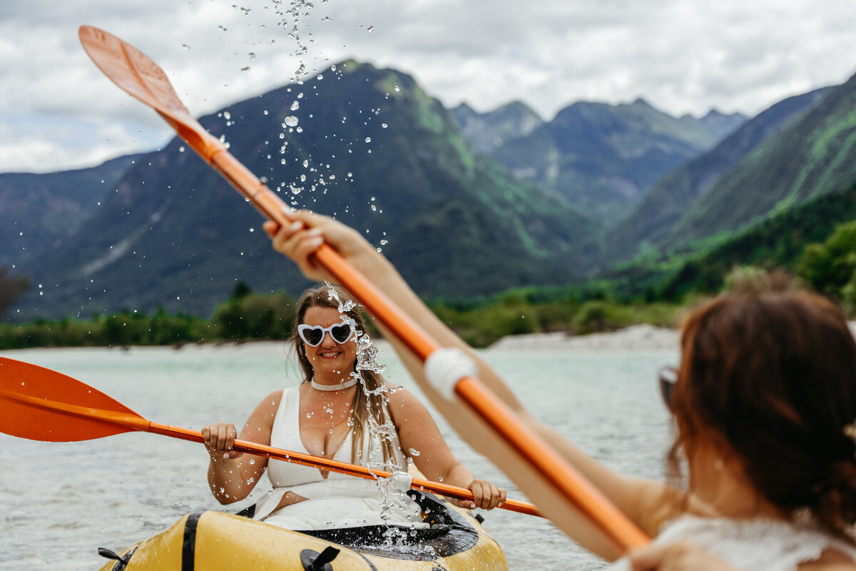 romantic couple in wedding dresses kayaking Soča River