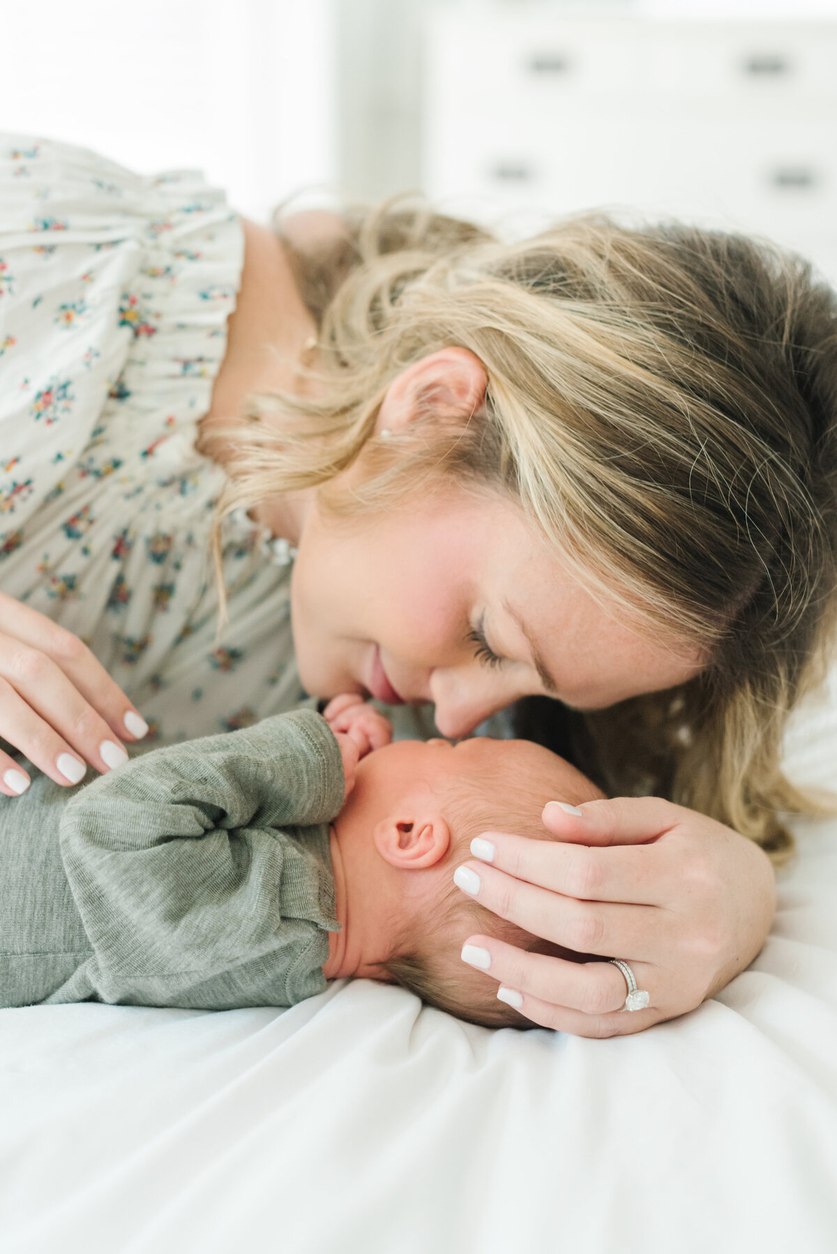 Mom touching noses with newborn in green onesie - Northern Virginia Newborn Photographer