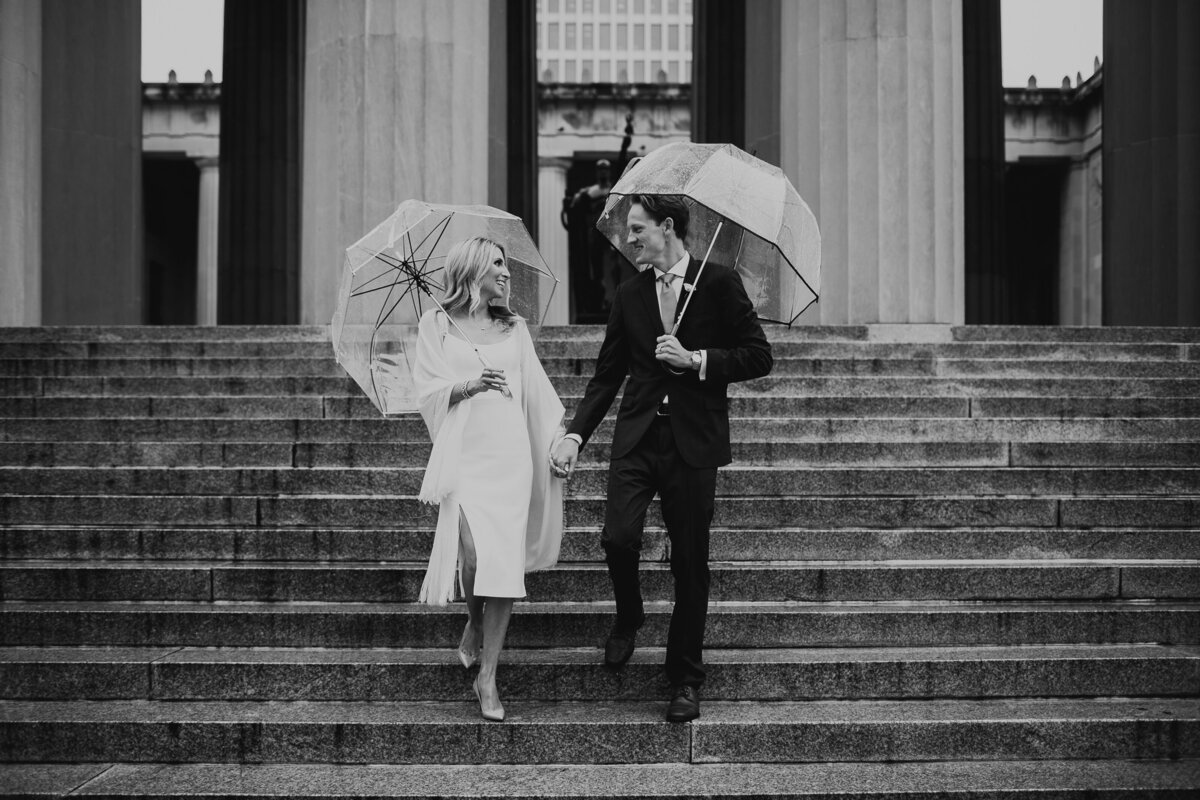couple married at courthouse holding umbrellas in the rain