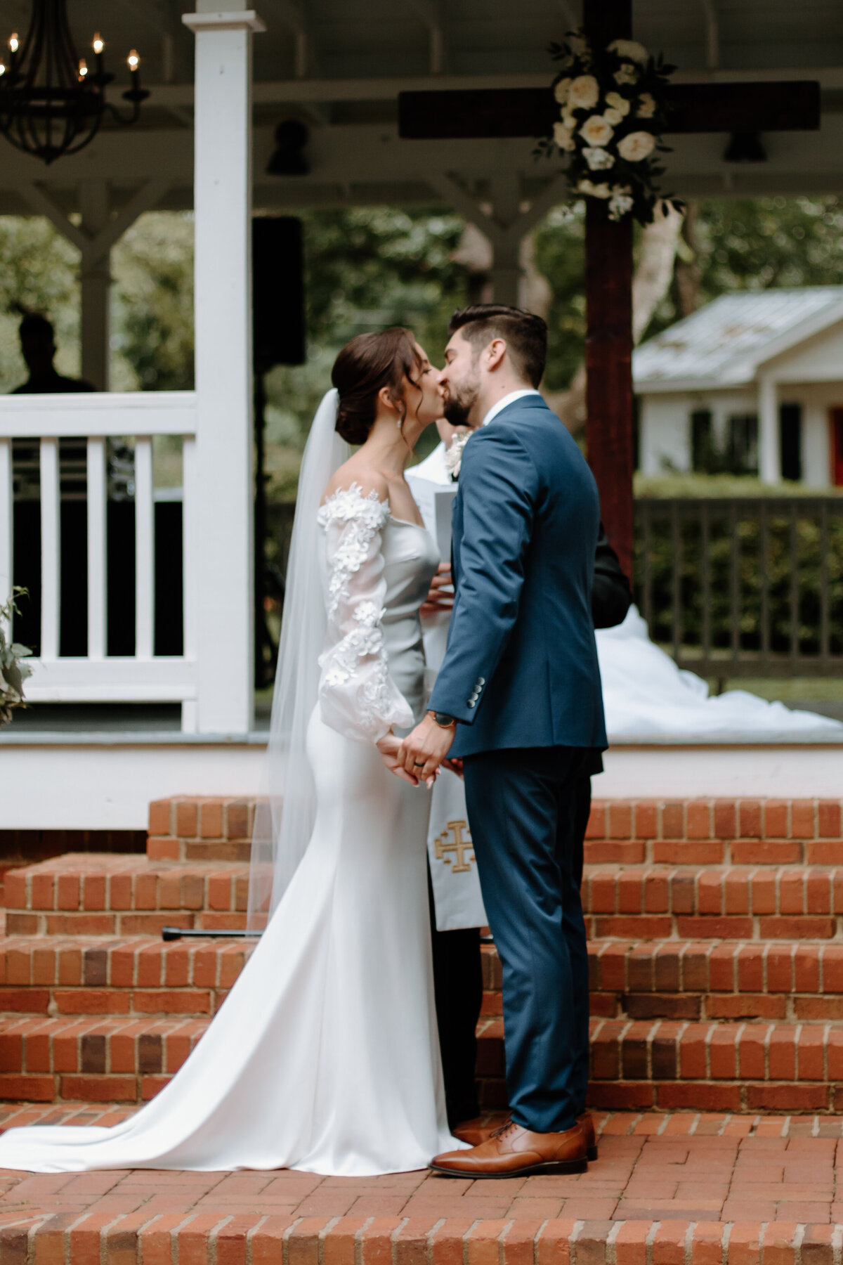 bride and groom kissing at the alter