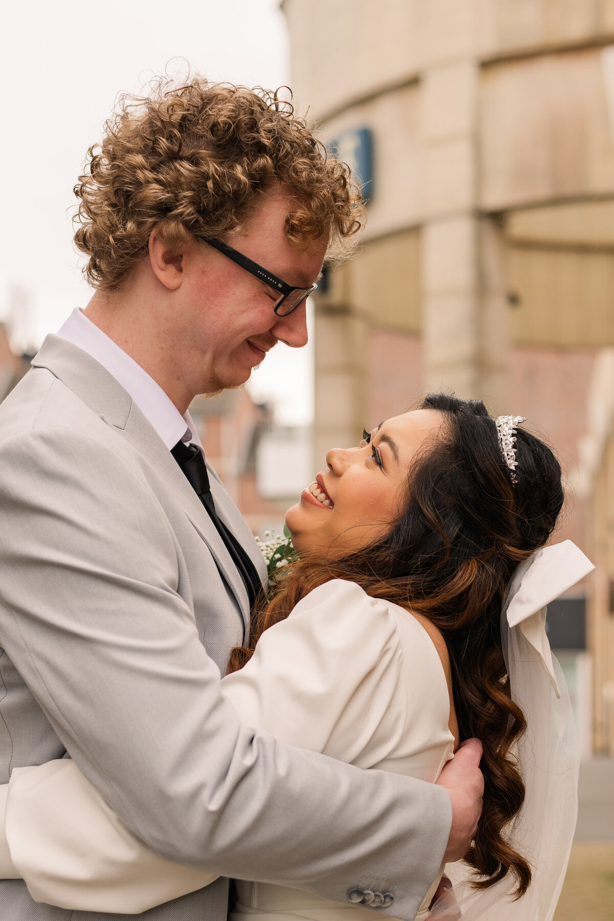 A bride and groom hug each other and look into each other's eyes outside of the gemeentehuis in Veldhoven after their ceremony
