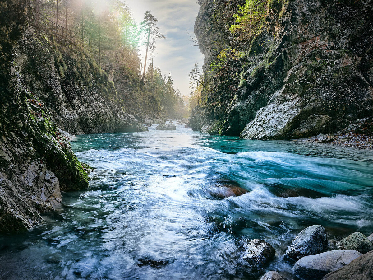Herbstliche Flusslandschaft an der Schlitza mit Felsklamm, Holzsteg und warmem Sonnenlicht – beeindruckende Naturaufnahme vom Fotograf Atelier Schulte – Spezialist für alpine Landschaftsfotografie in Italien.