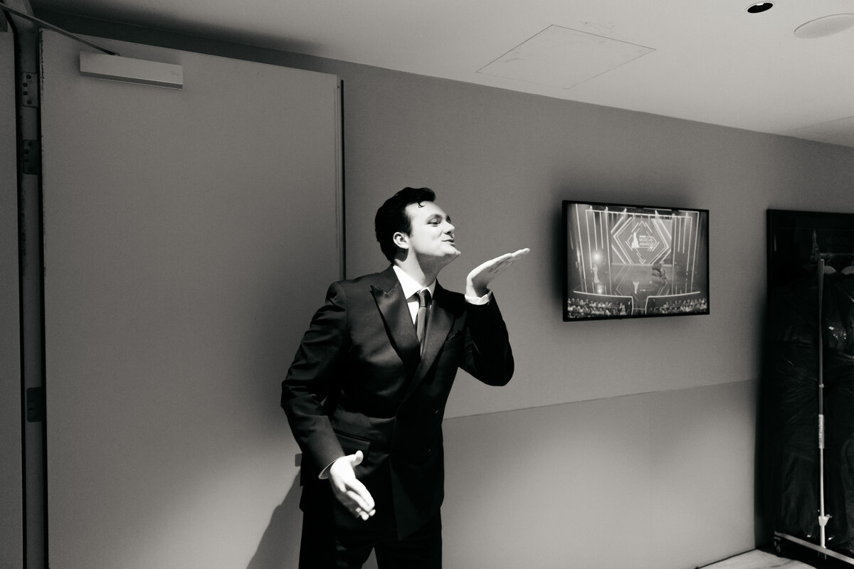 Acteur backstage theater geeft handkus naar collega.
