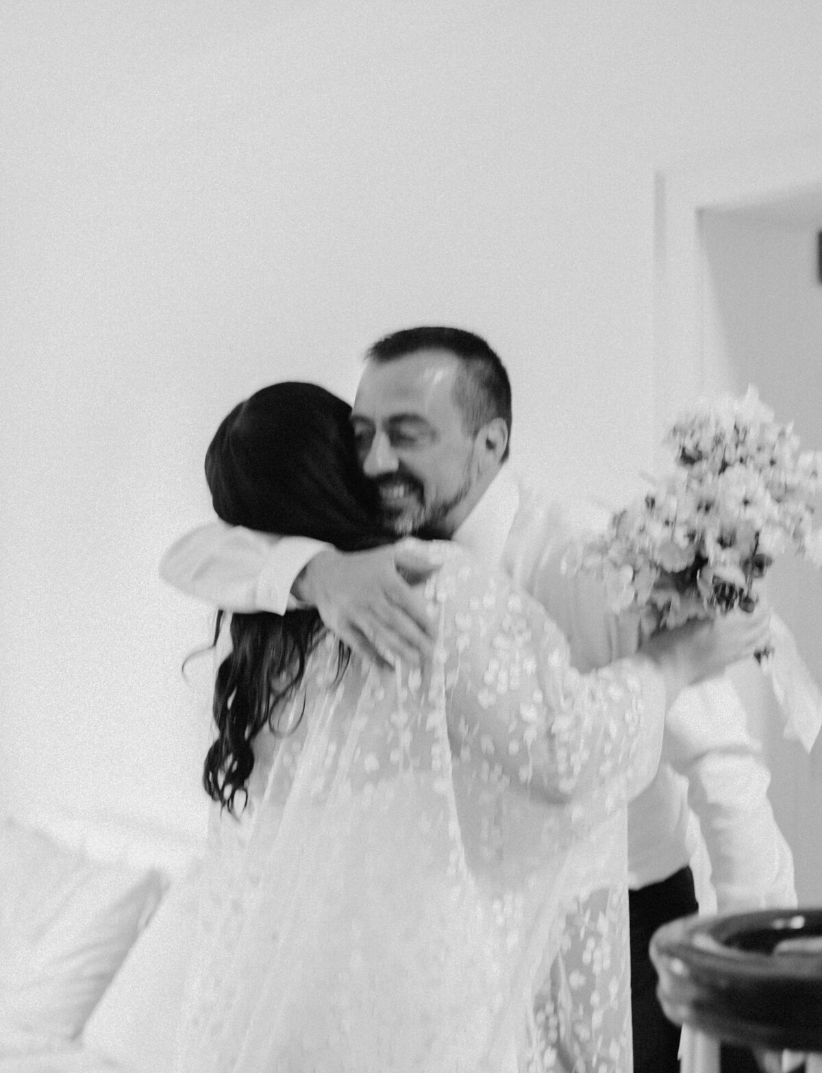 candid wedding photography, natural, movement black and white wedding photo of bride's father smiling and hugging
