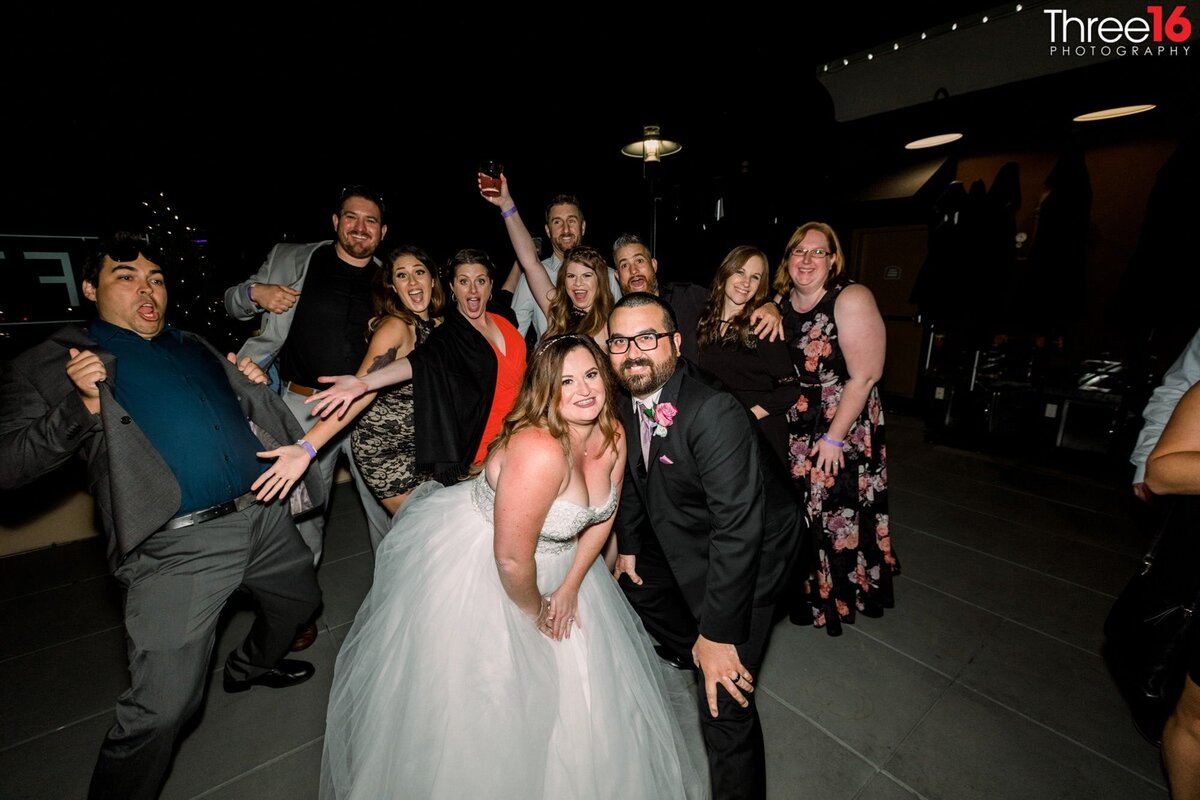 Bride and Groom pose with family and friends at the reception