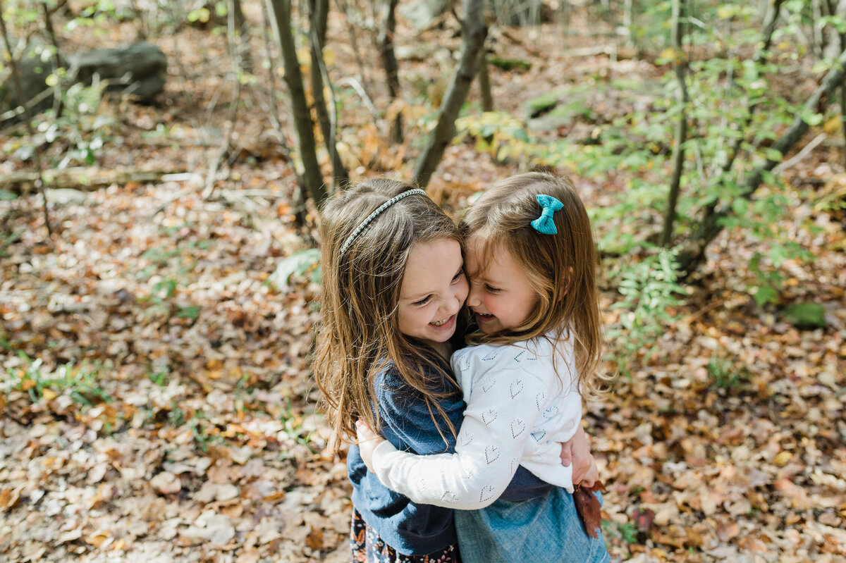 Little girls hugging during fall family photoshoot.