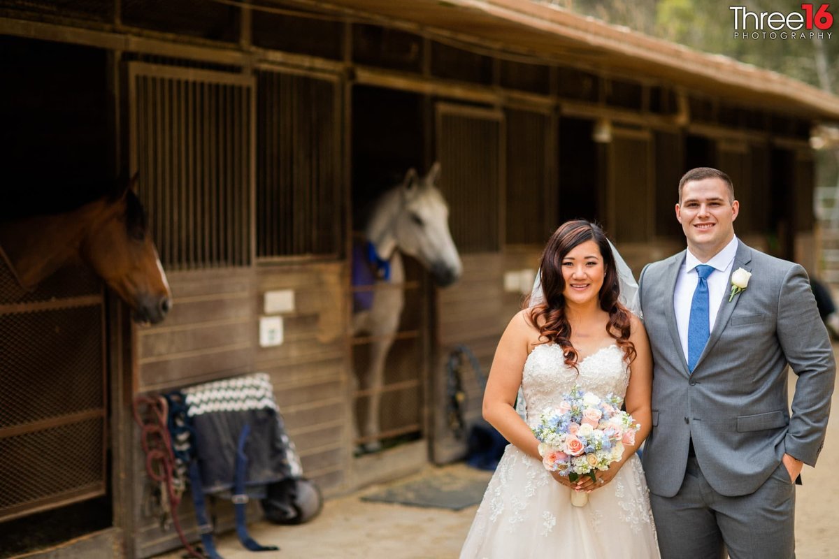 Bride and Groom pose outside the horse stable area
