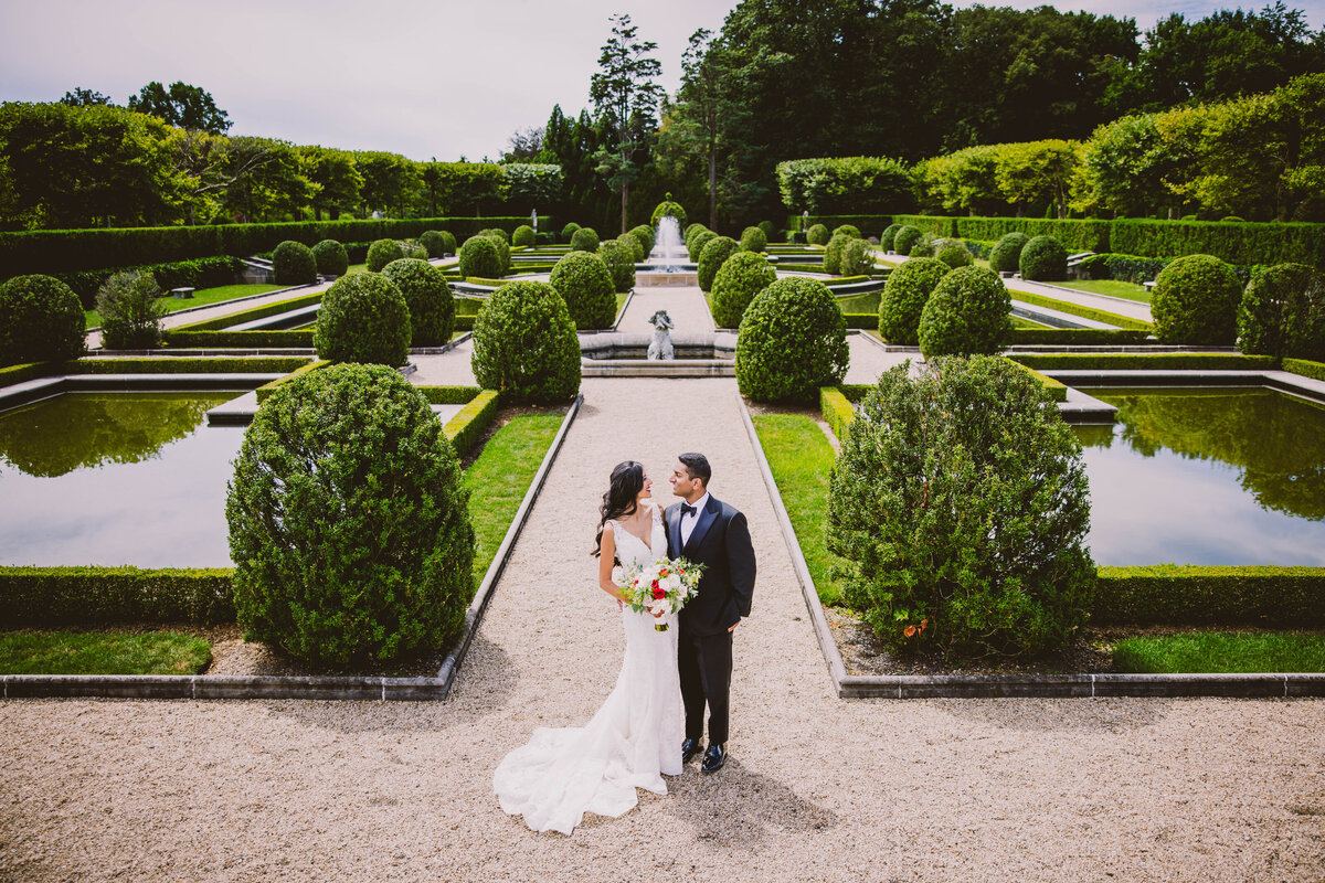 Indian wedding bride and groom looking at each other in a garden at the oheka castle in huntington ny