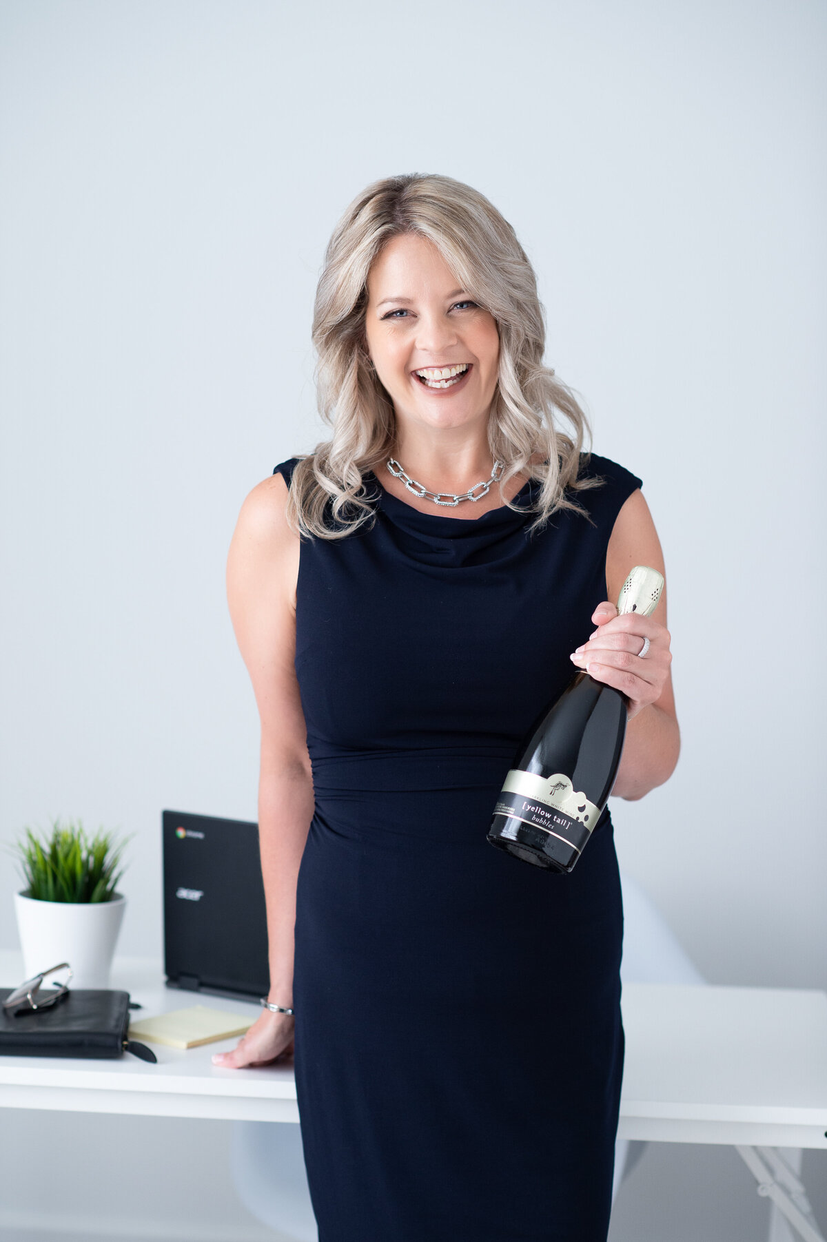 Ottawa branding photography showing a realtor holding a bottle of champagne.  Captured in studio by JEMMAN Photography Commercial