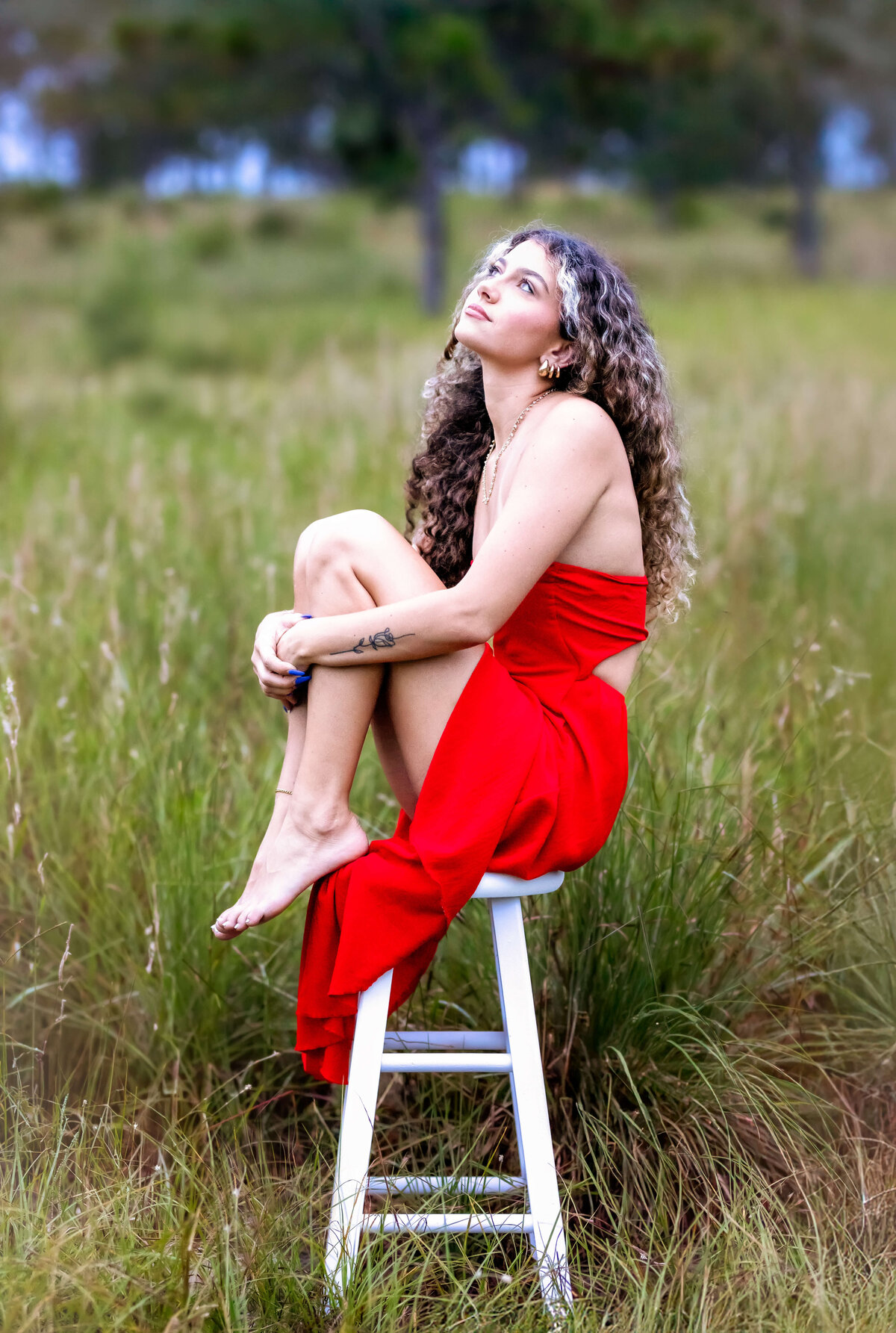 Orlando senior photographer captures a stylish portrait of a teen girl posing on a stool.