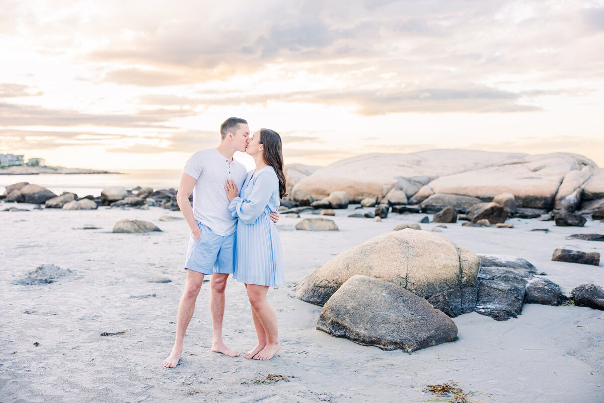 Couple hugging and kissing during Massachusetts beach engagement session
