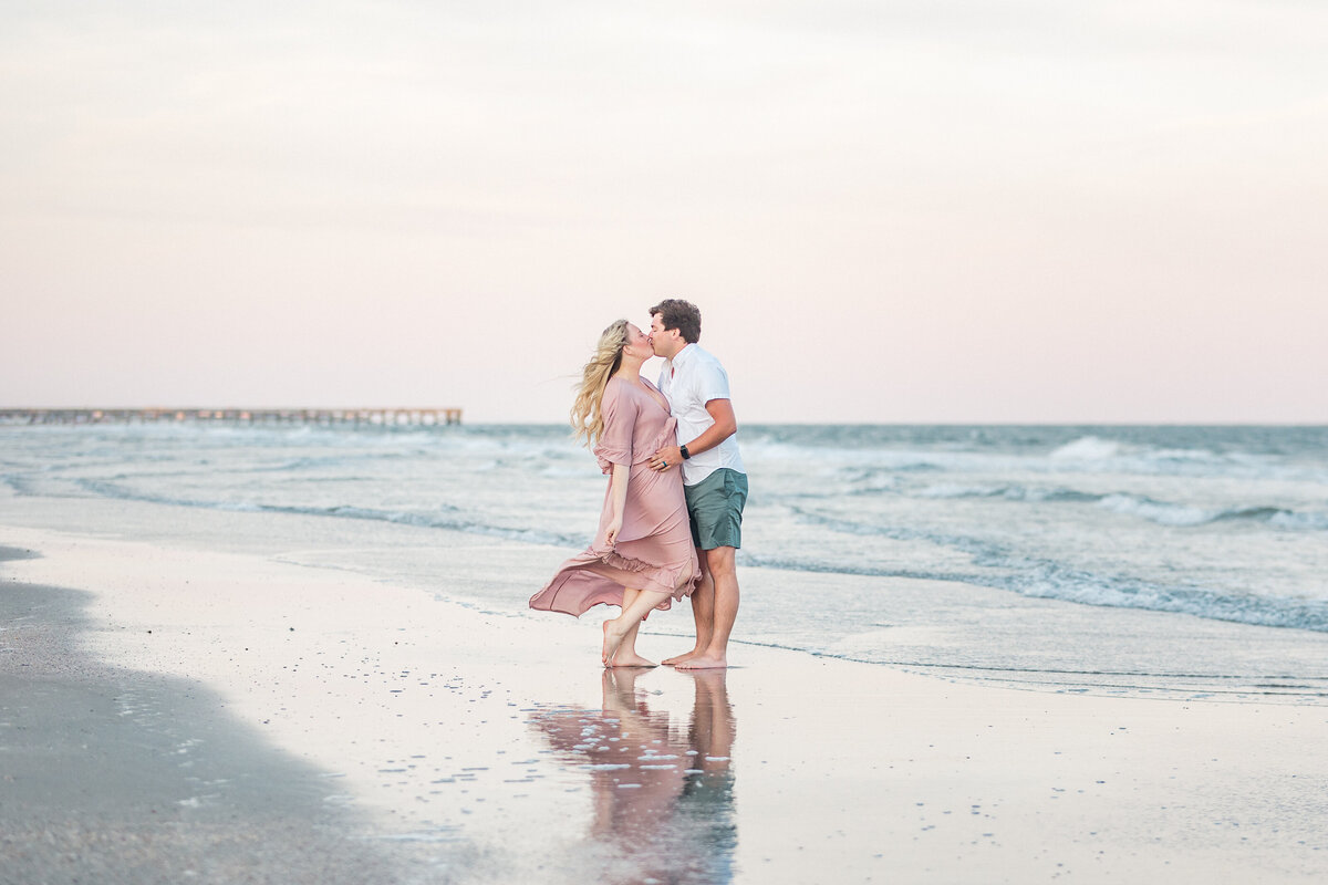 Couple shares a kiss on the beach of Summerville Island for portrait session with Karen Schanely