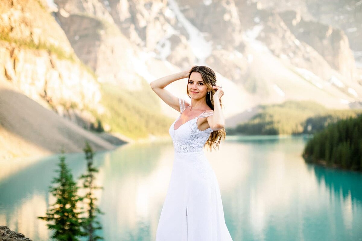 Moraine-Lake-behind-the-bride-as-the-bride-looks-into-the-camera-after-the-couples-elopement