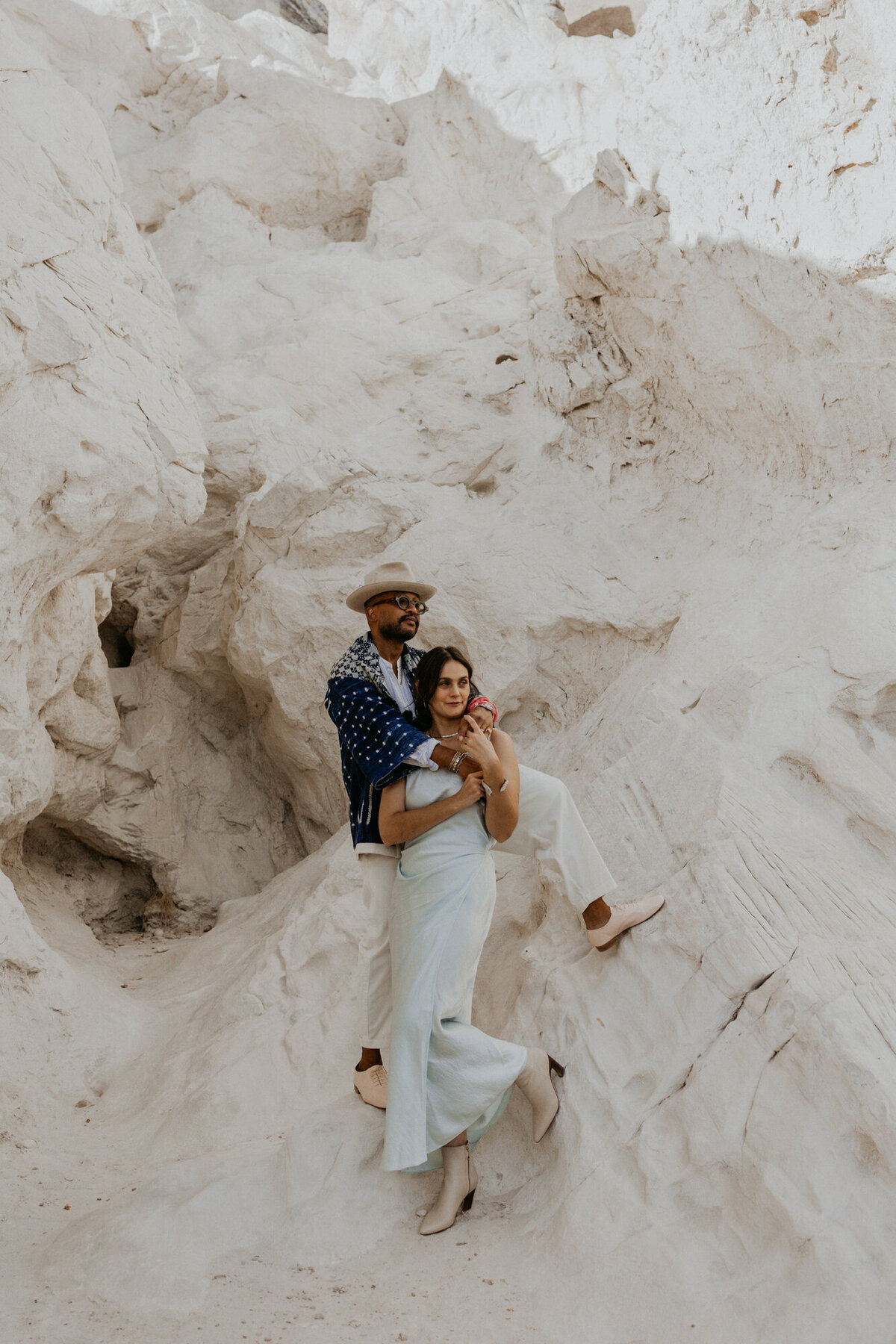 bride and groom sitting together on a white rock formation