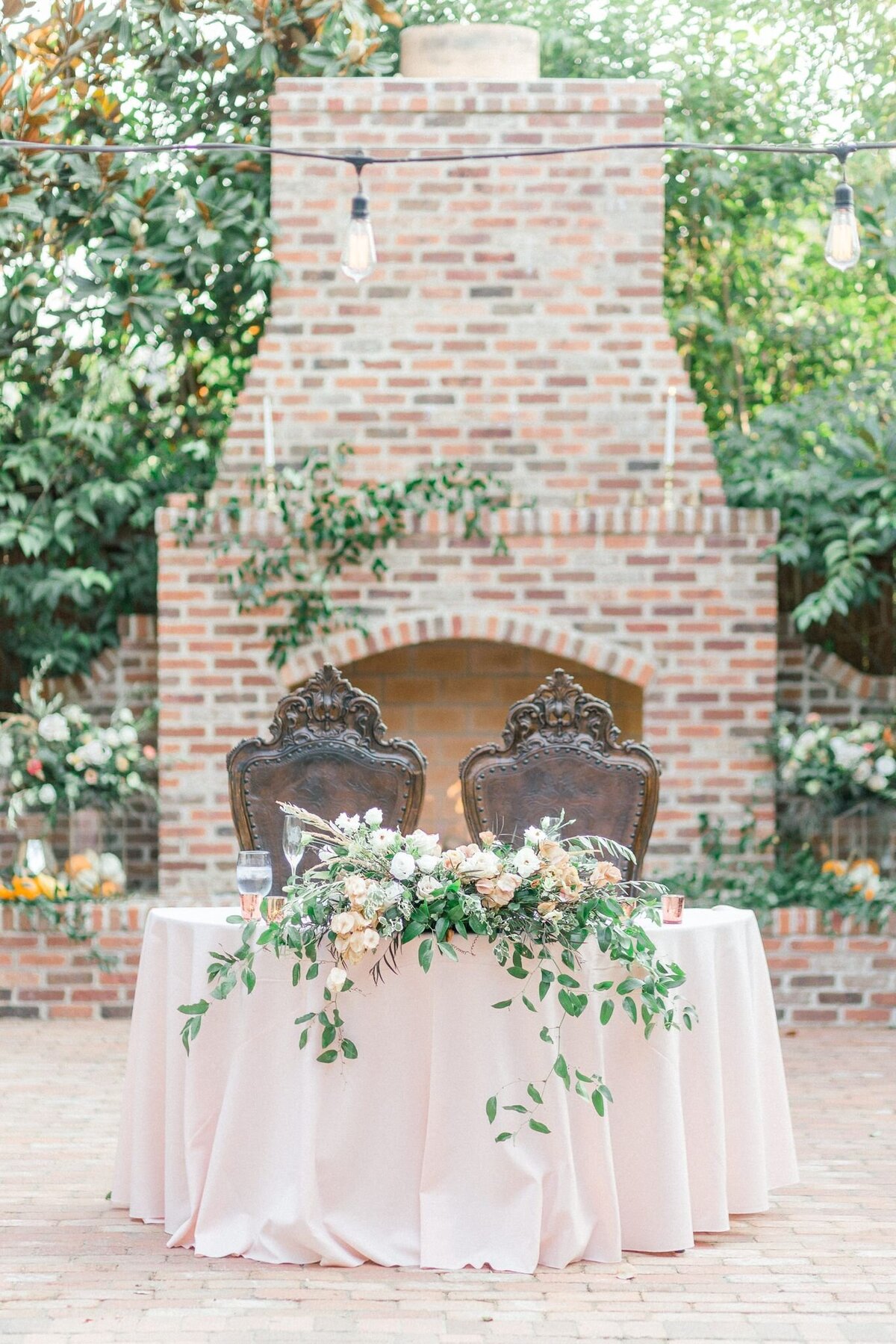 The bride and grooms dining table is full of fresh flowers and greenery.