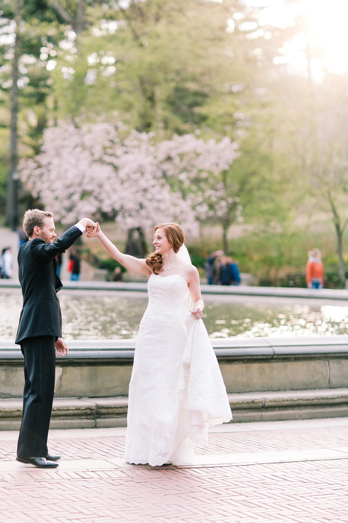 Groom twirling his bride at sunset in central park