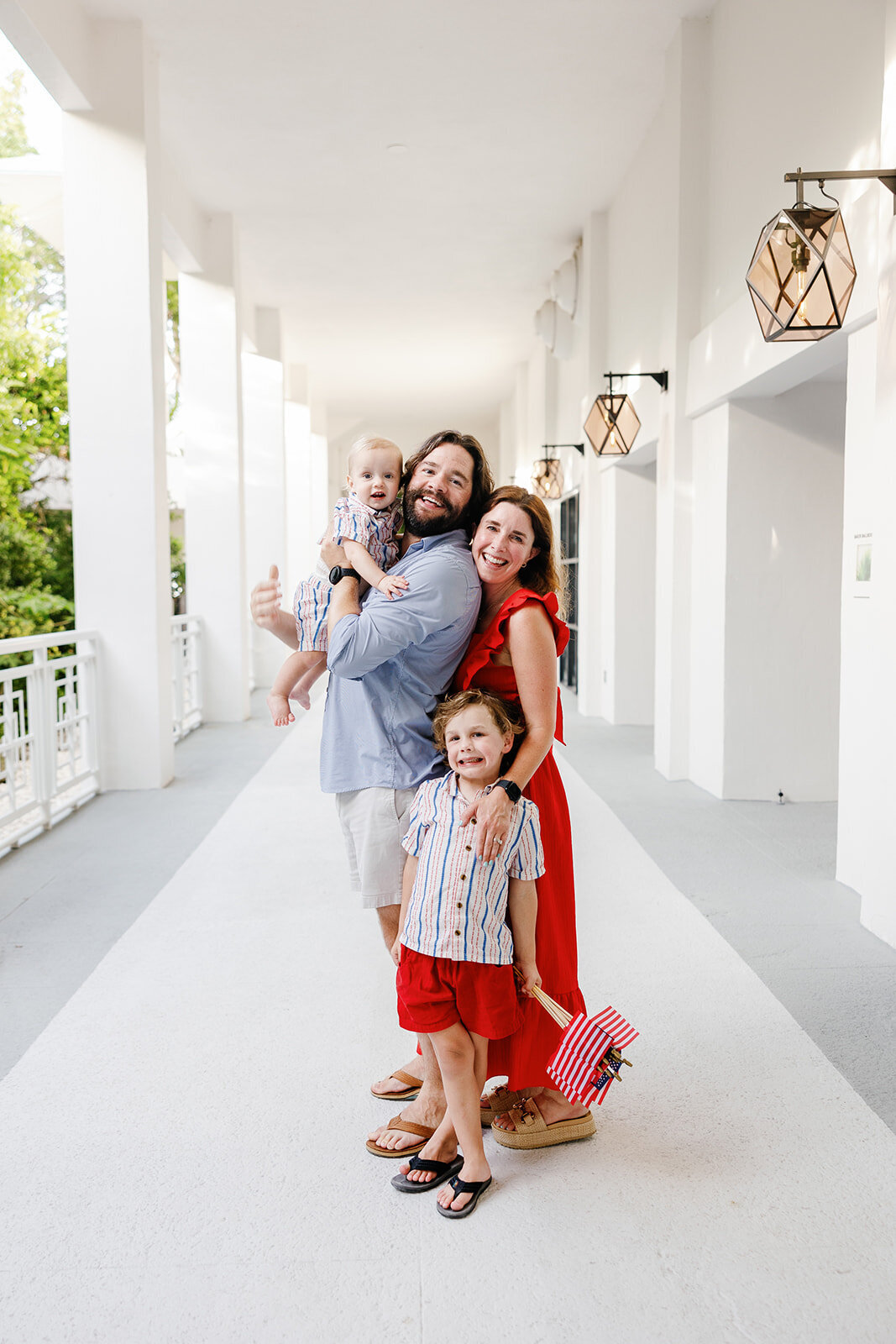  A happy family embraces in a bright hallway, radiating warmth and love during a Florida Keys portrait session.