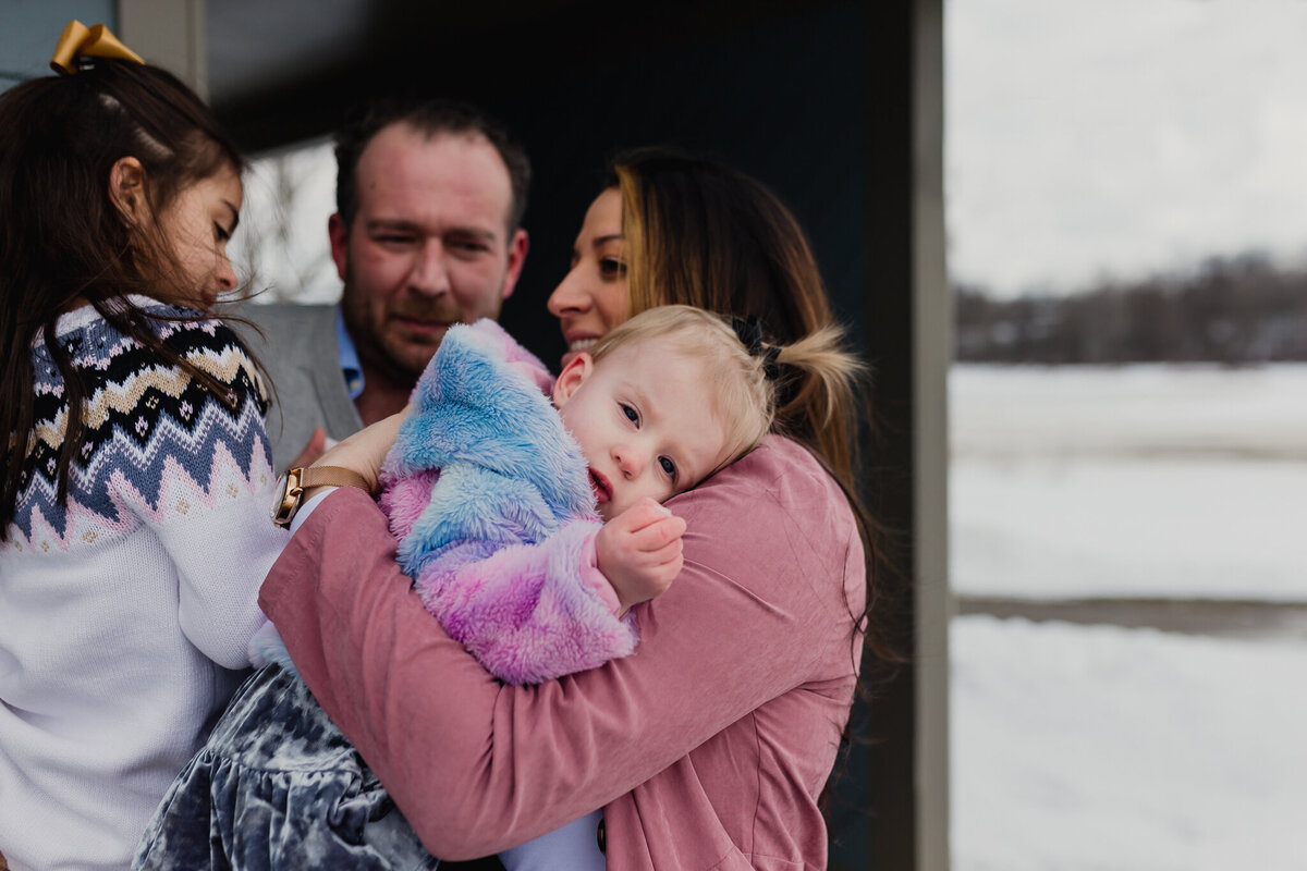 Mom, dad and two children hug.