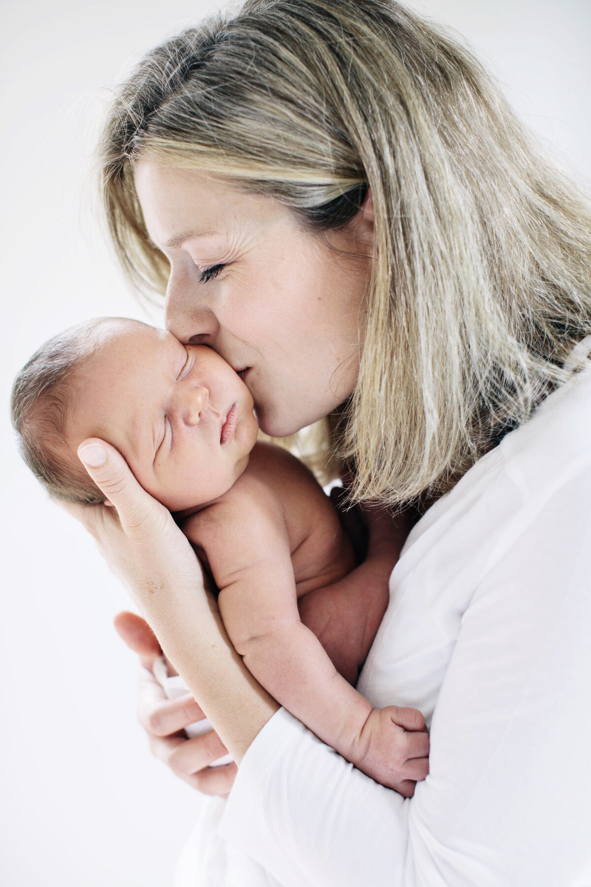 mother kissing baby at Newborn session new hampshire