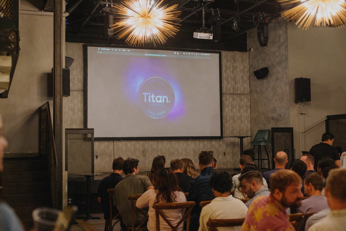 Guests seated indoors for a presentation during Titan Day 3.