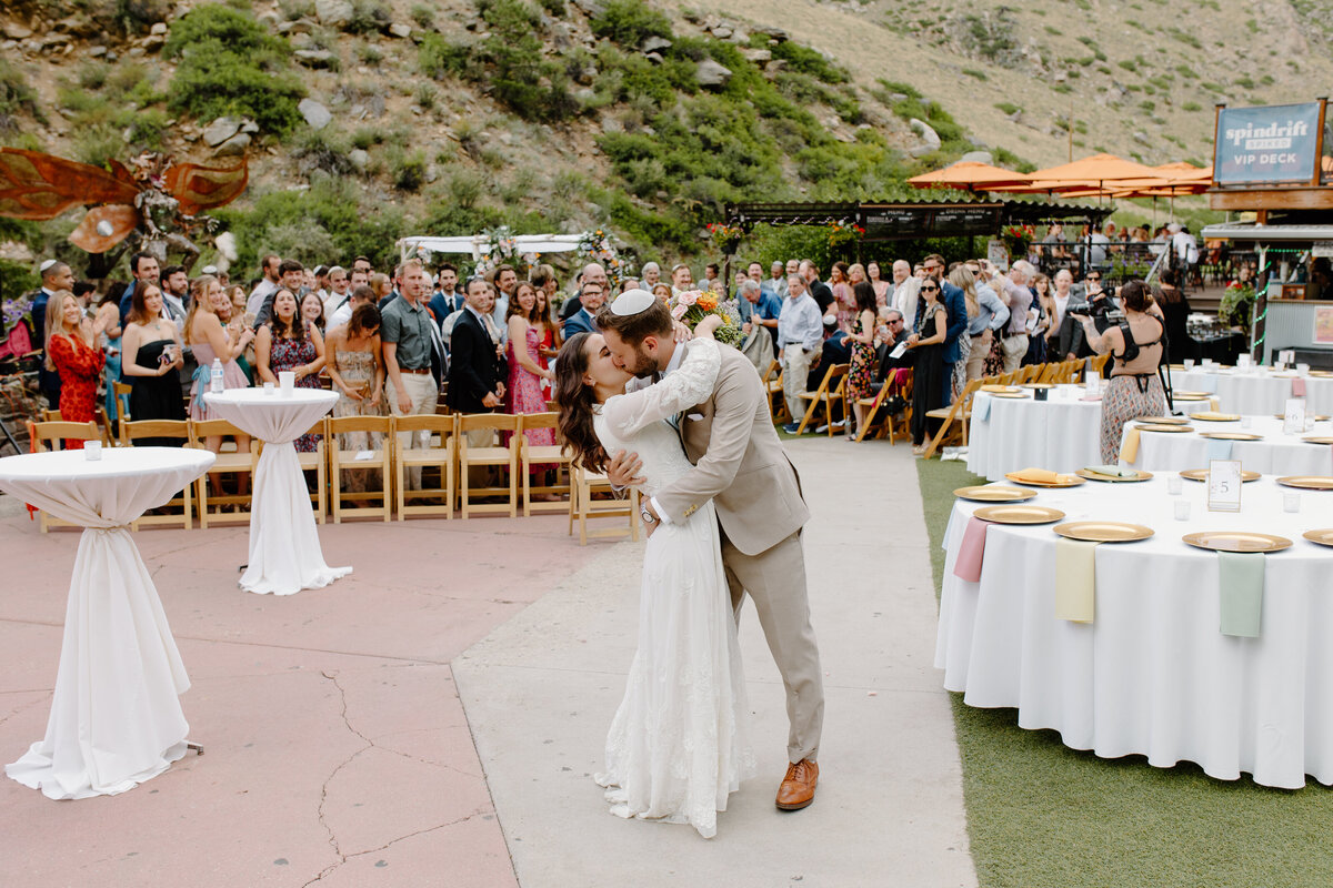 A bride and groom kiss after their wedding ceremony at The Mishawaka in Bellvue, Colorado