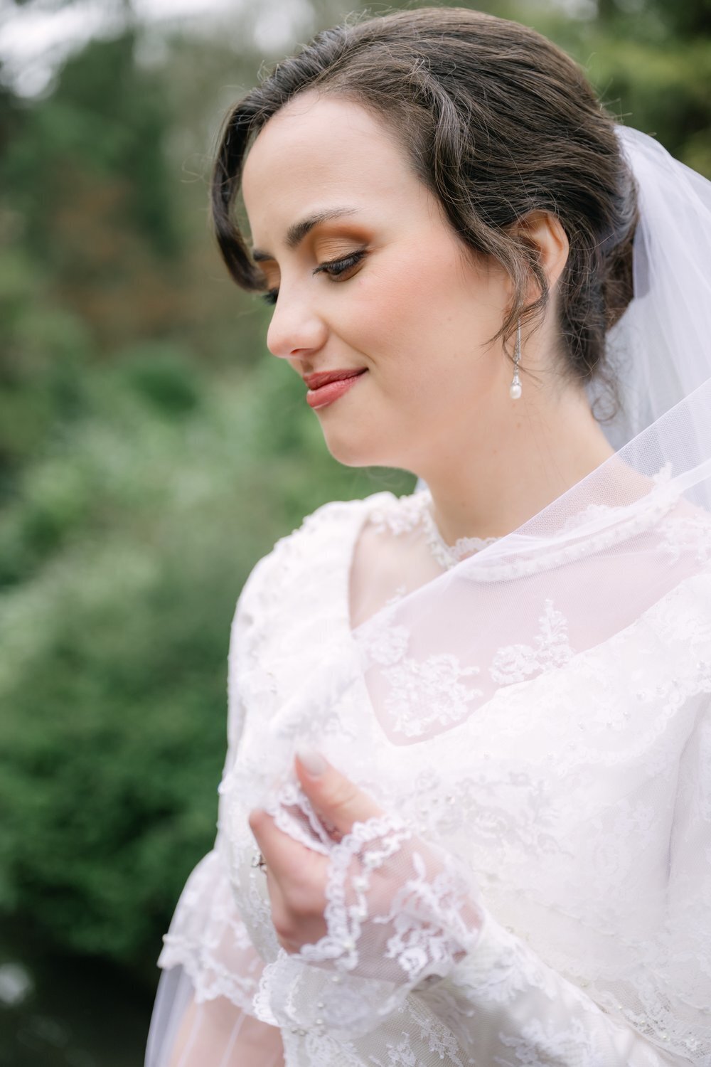 close formal portrait of bride in antique dress and veil outdoors