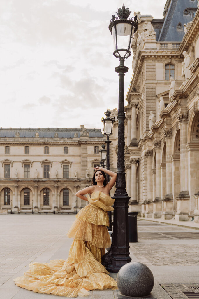 Elegant Paris portrait at Louvre courtyard with woman in golden gown by vintage lamppost