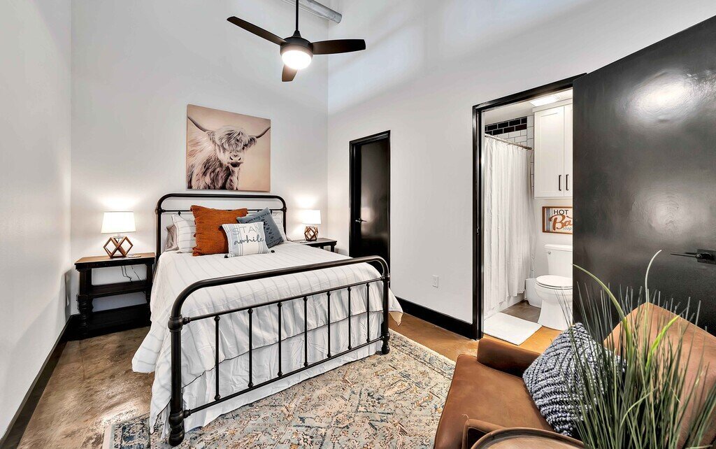 Bedroom with Queen bed and private bath in this industrial two-bedroom, two-bathroom first floor rental condo in the historic Behrens Building in downtown Waco, TX.