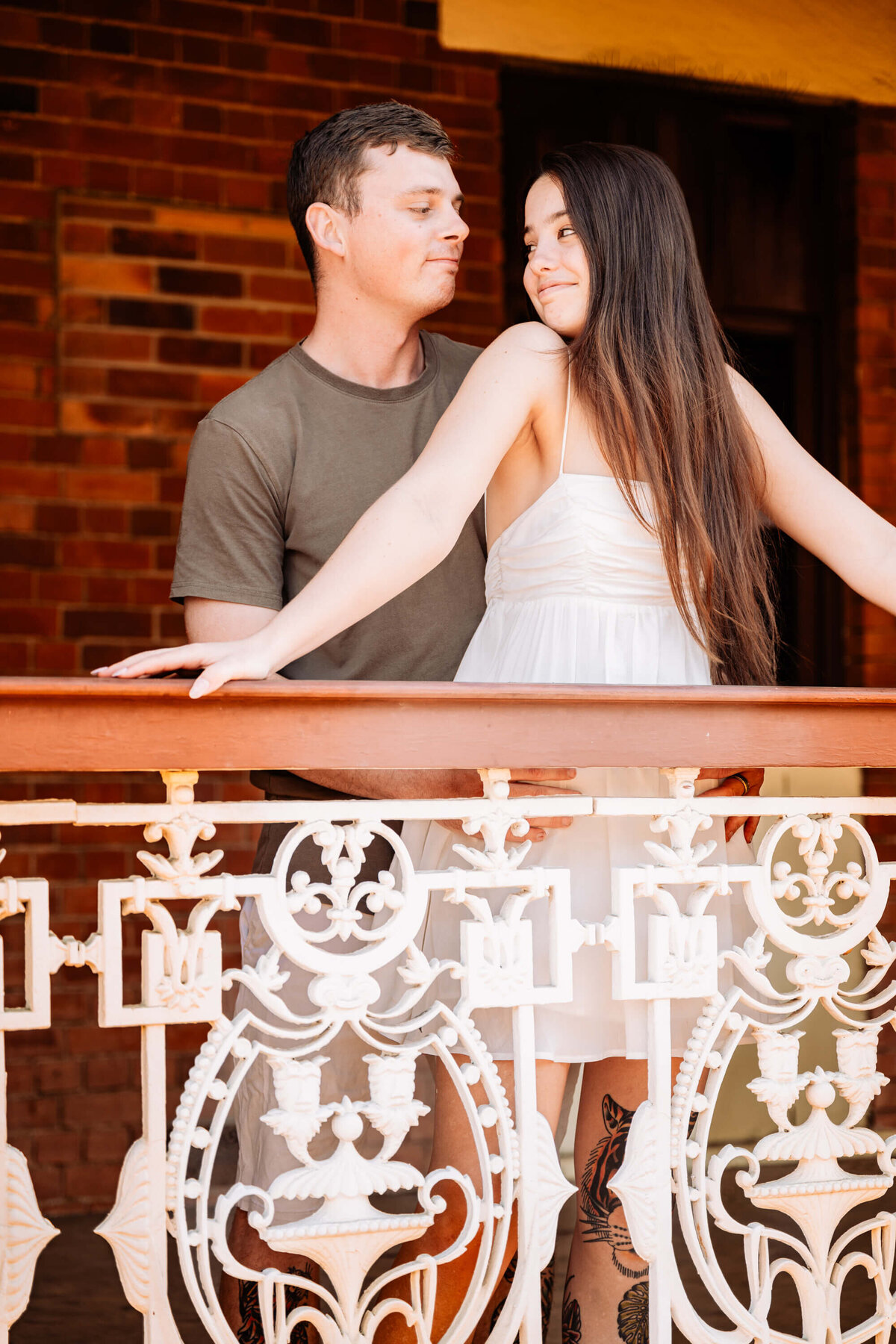 A man and woman stand together on a balcony, enjoying the view and each other's company. - photo by Jamie Simmons