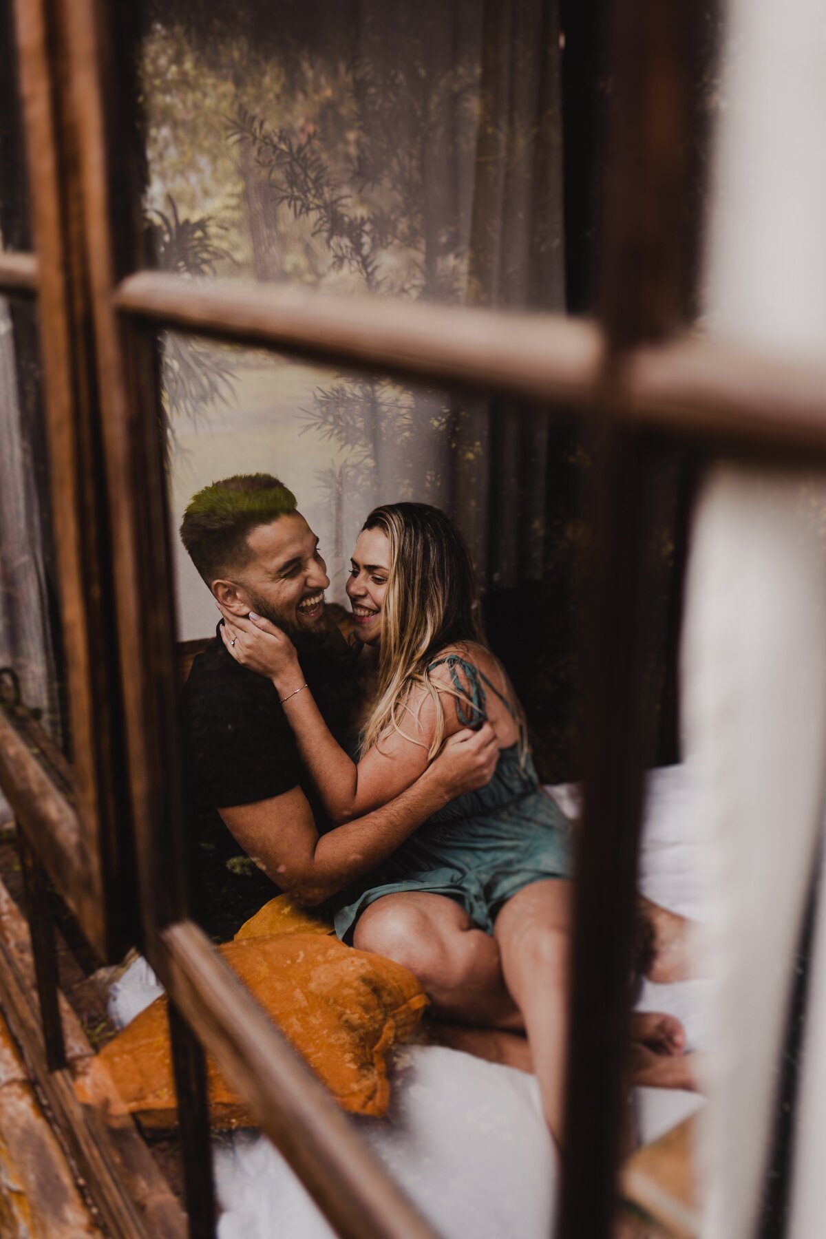Looking into a window at a couple embracing each other and laughing together