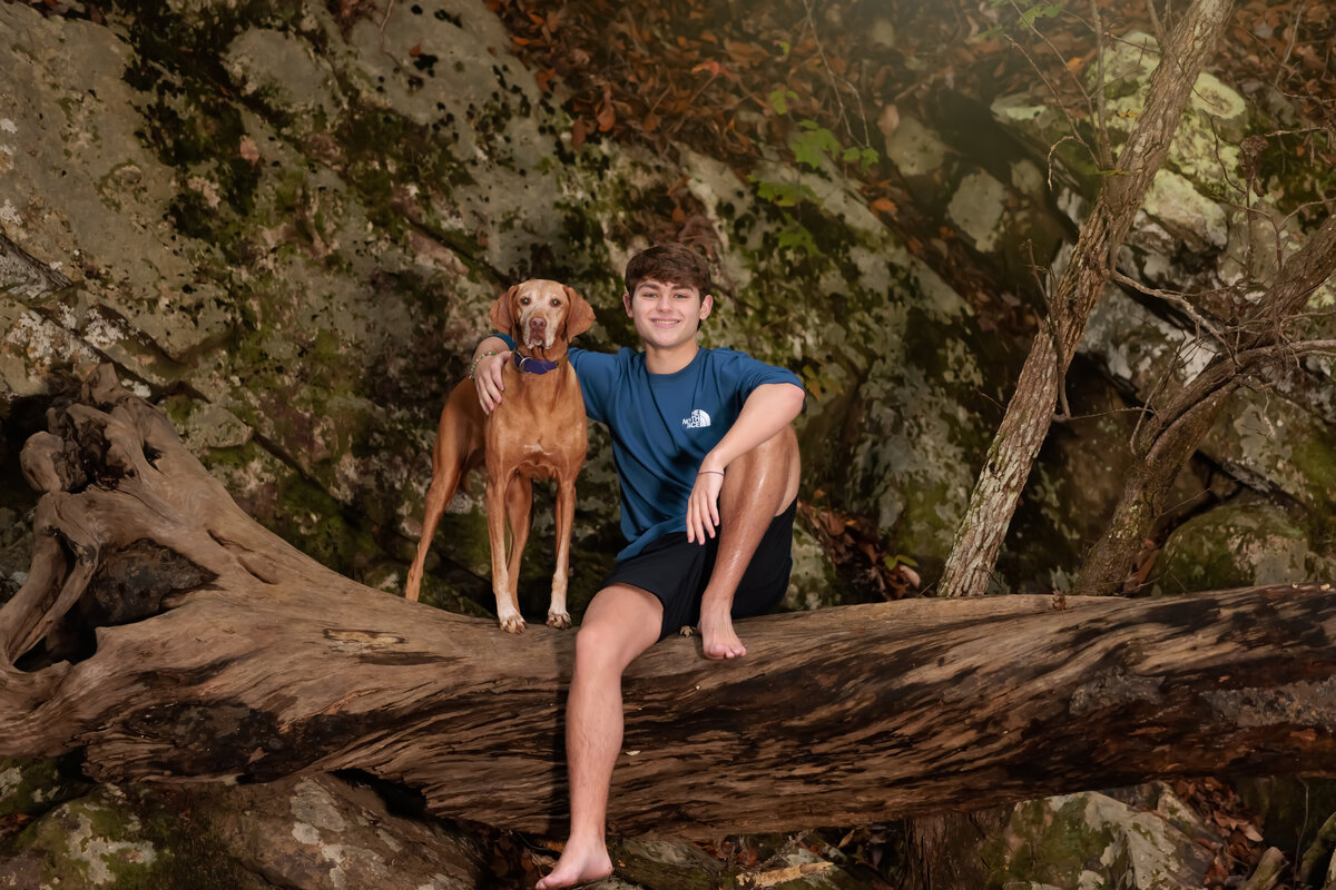 High School Senior guy with his dog sitting on a big tree in Durham NC>