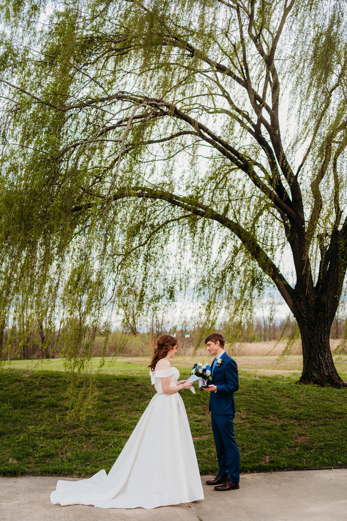 Elopement ceremony beneath a large willow tree in spring