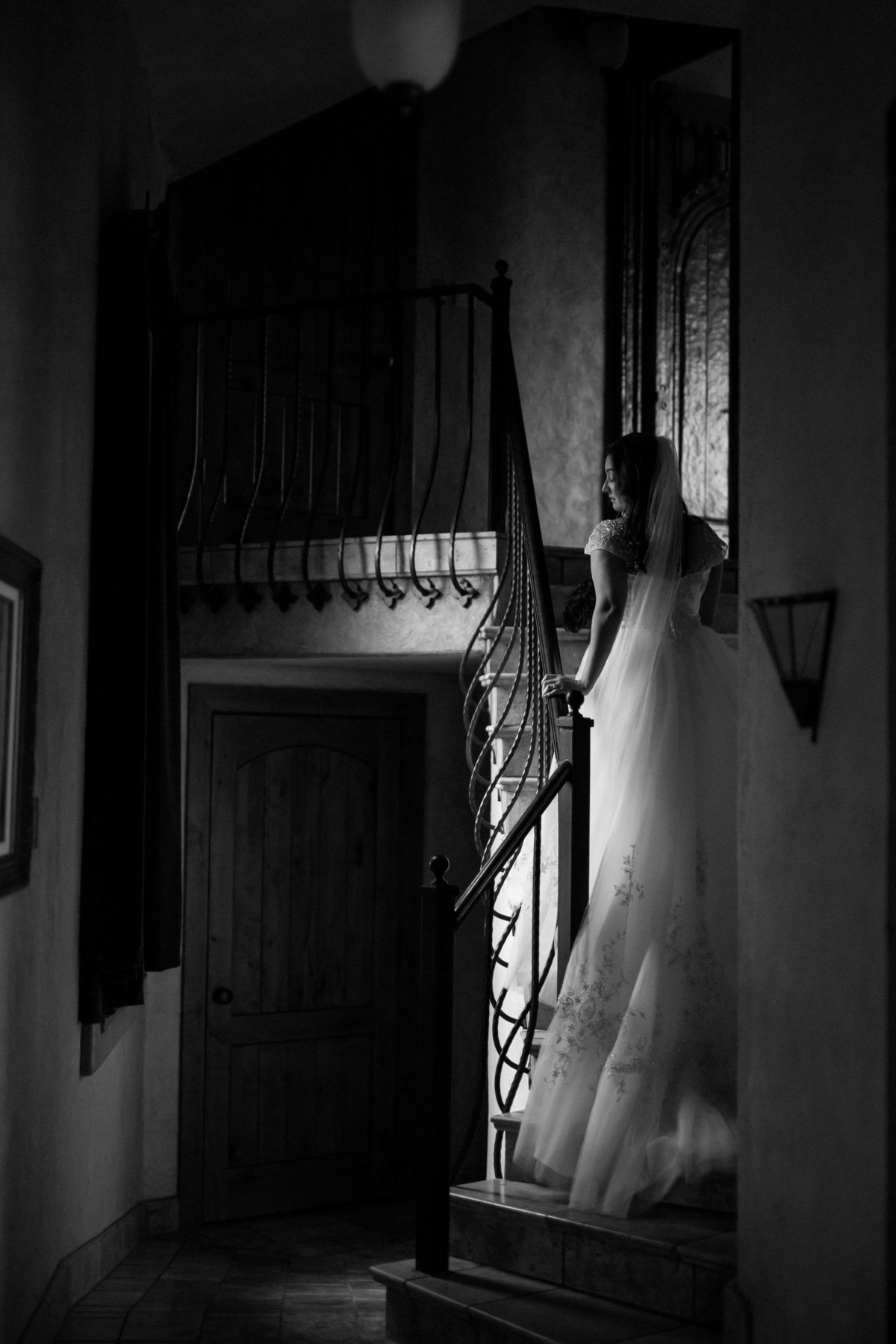 bride standing on staircase staring through window for bridal taken by San Antonio wedding photographer Expose the Heart