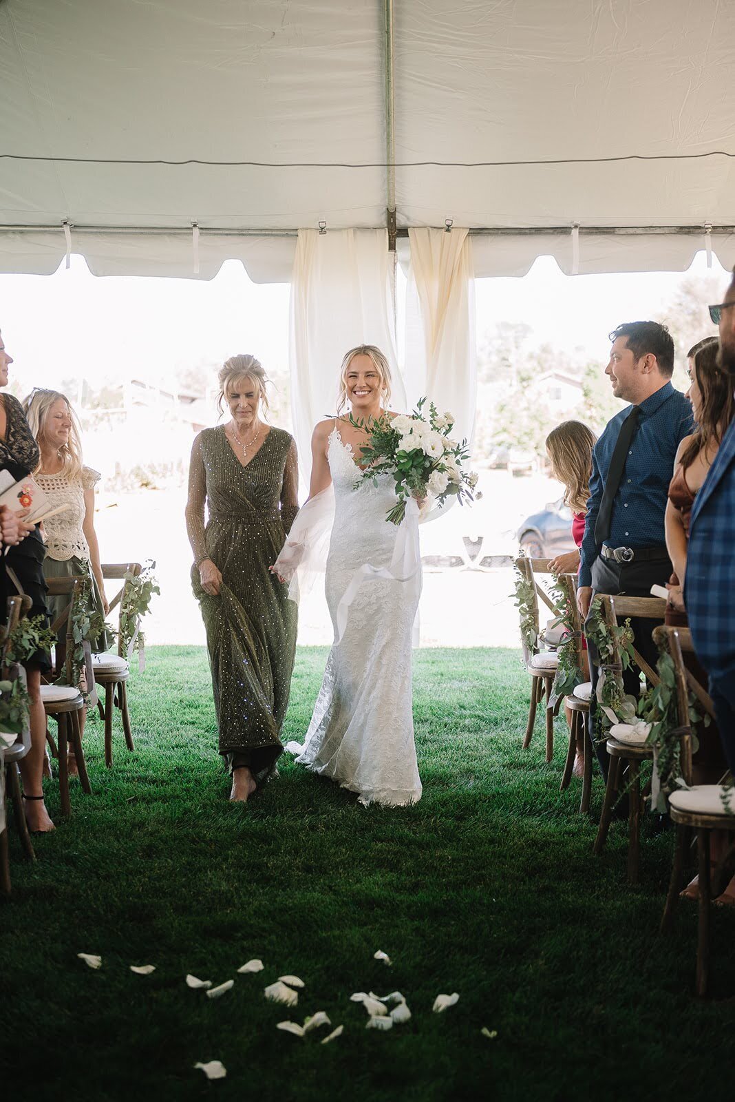 Bride walks down the aisle with an all white and greenery bouquet with her mother in Colorado.