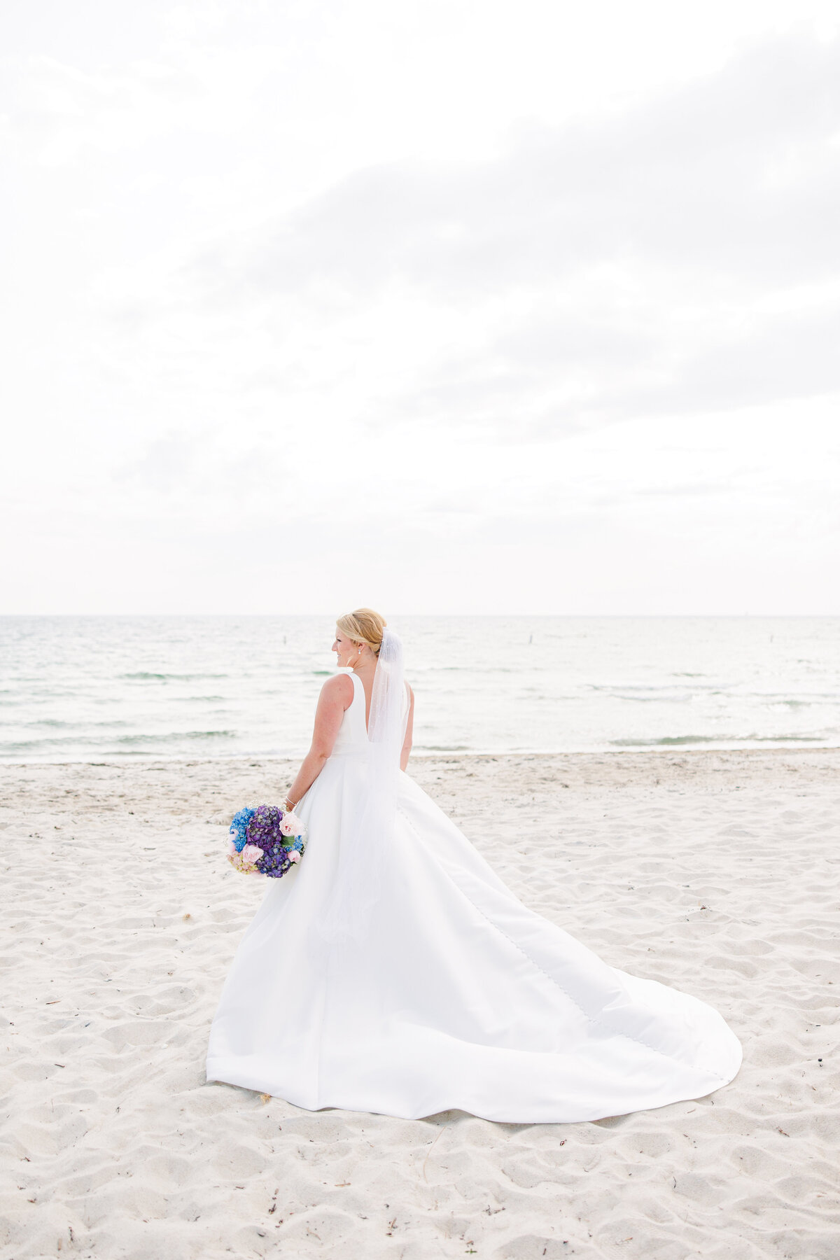 Bride looking at the ocean representing Cape Cod wedding photography