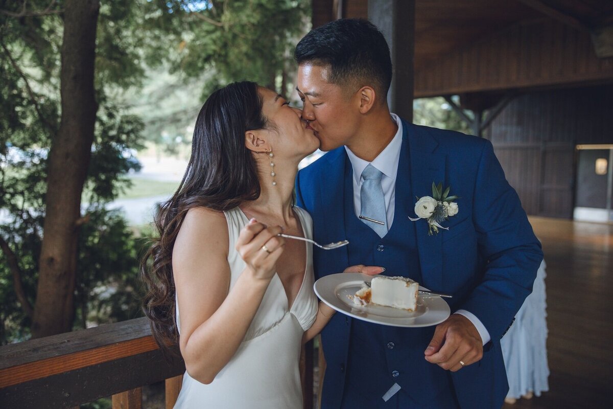 Bride and groom laughing during cake cutting moment