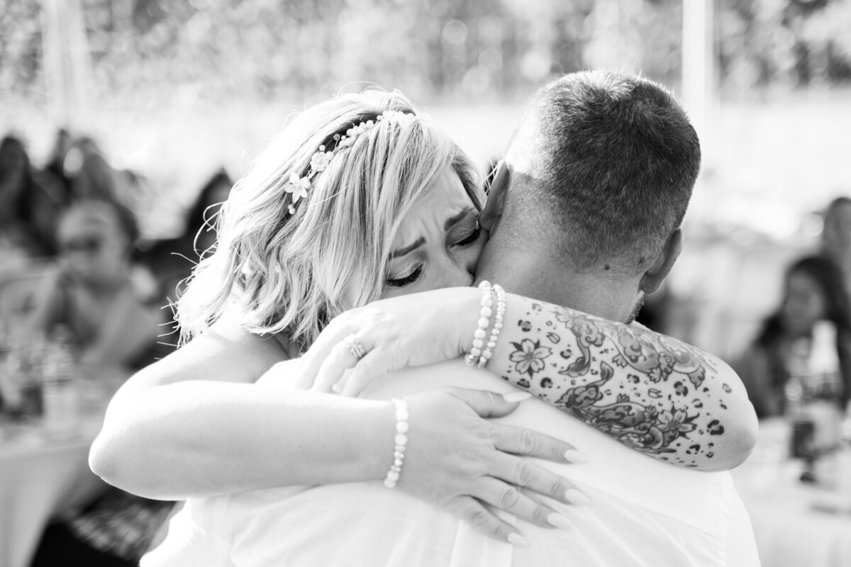 Bride gives her groom an emotional hug during their first dance at their backyard wedding in Galloway, Ohio.