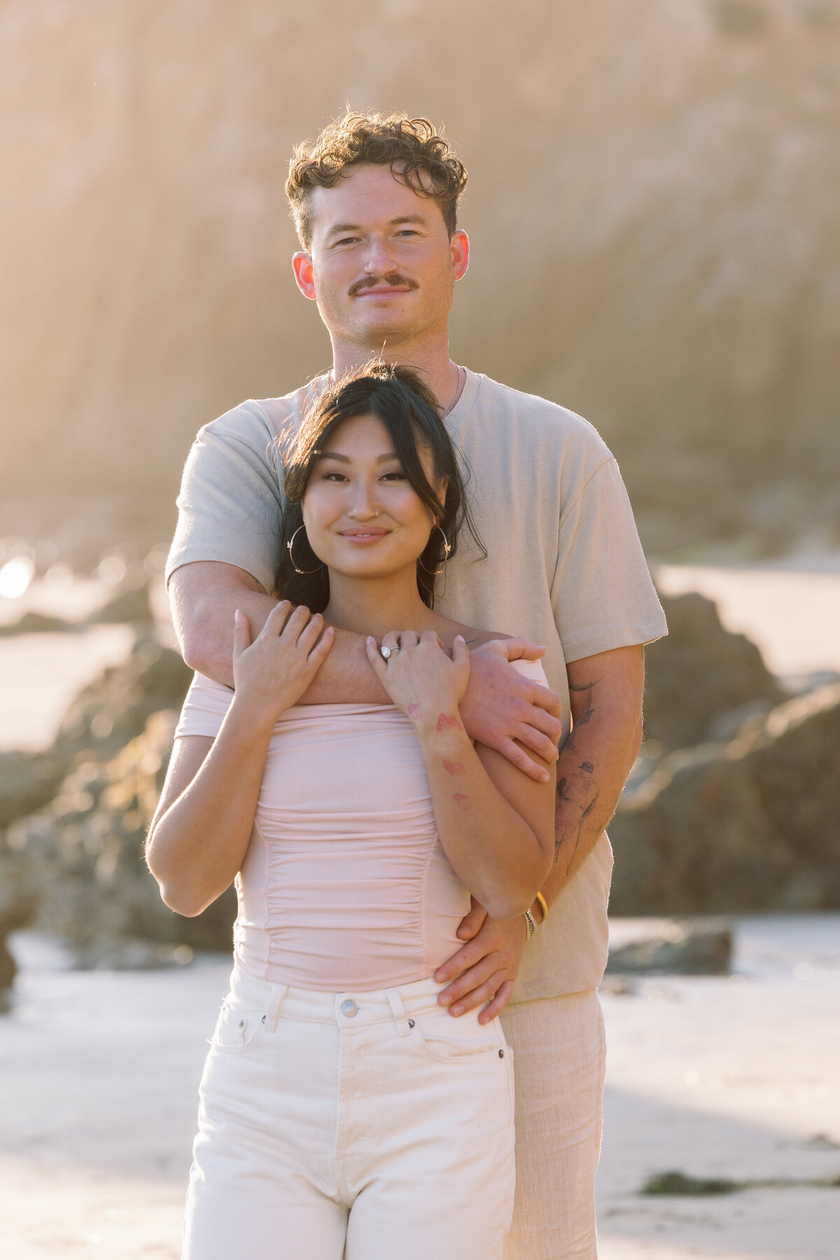 A person standing behind their partner with their arm around their shoulders