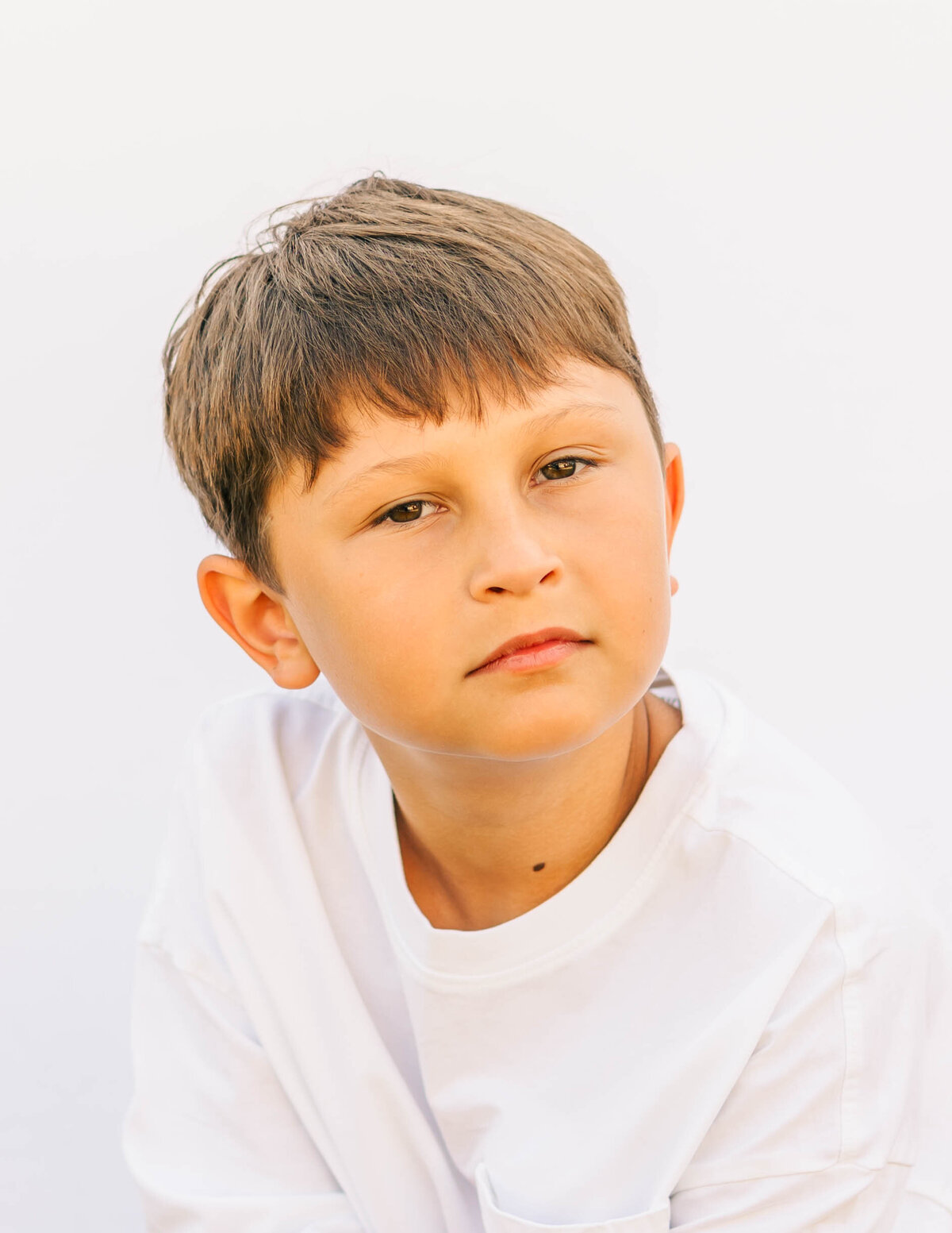Close-up fine art portrait of 5th-grade boy with genuine smile