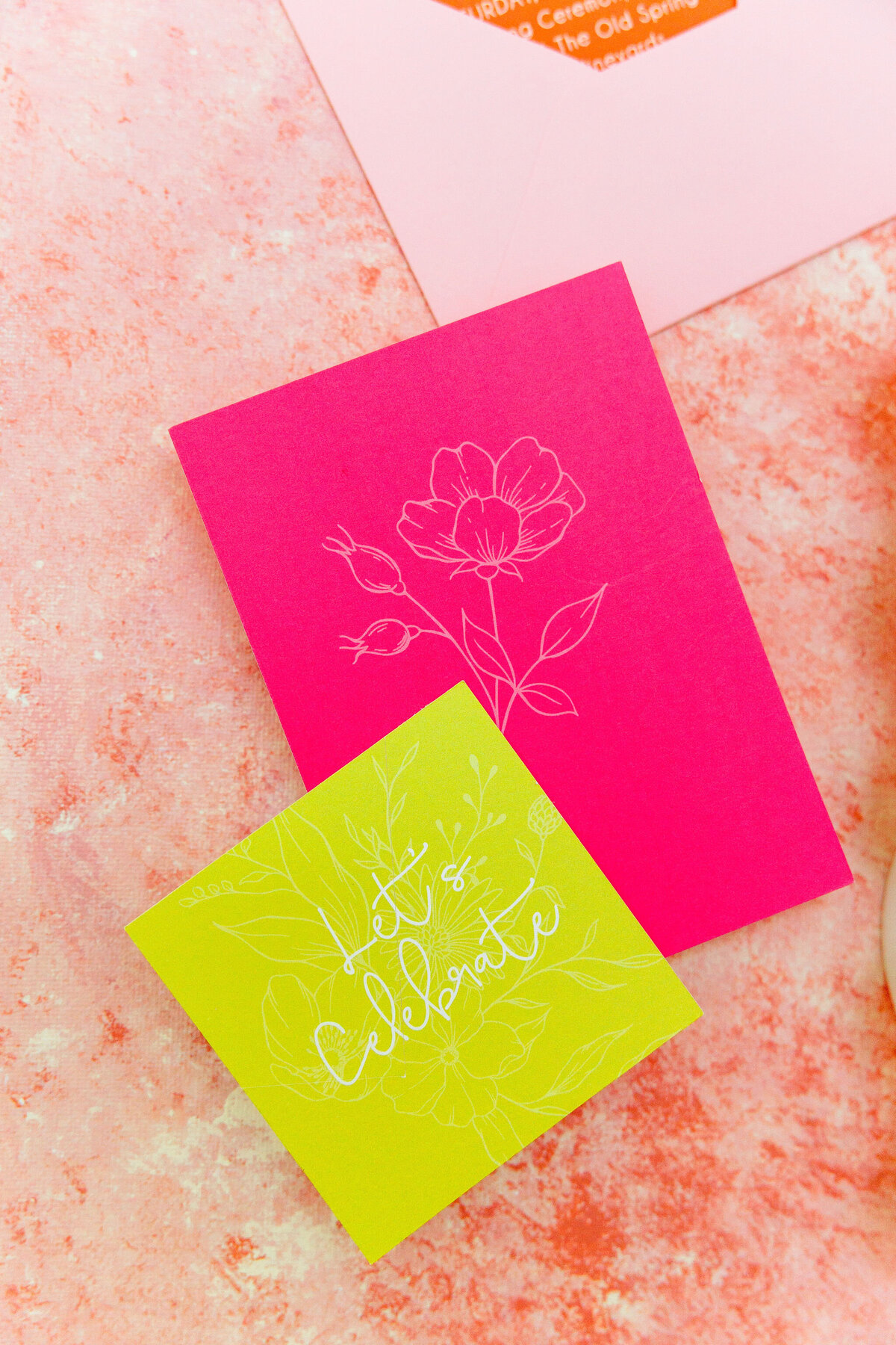neon-wedding-card-orange-and-pink-flatlay