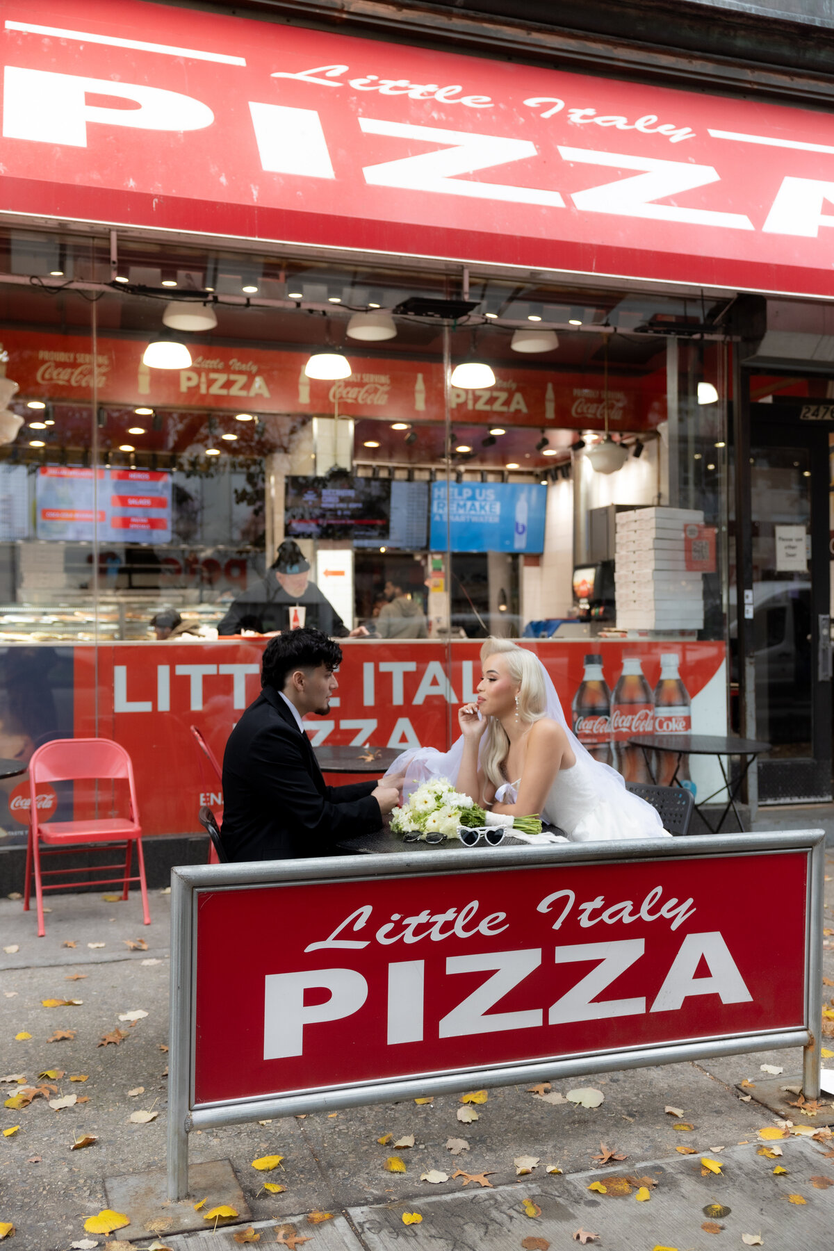 Neon sign glowing in an NYC pizza shop, captured during the couple’s urban elopement session.