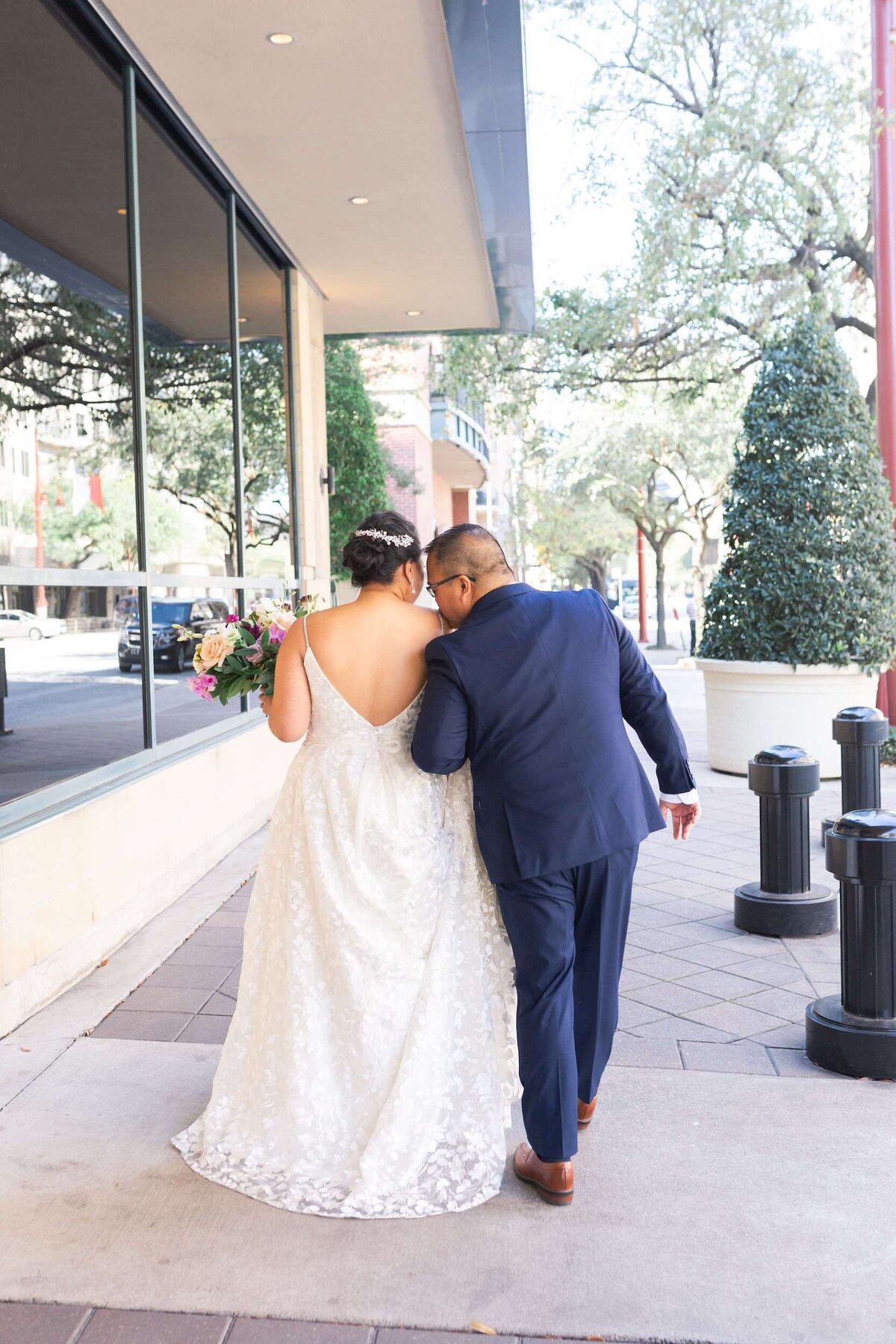 groom kisses his bride on their wedding day at The Westin in Houston Texas by Swish and Click Photography