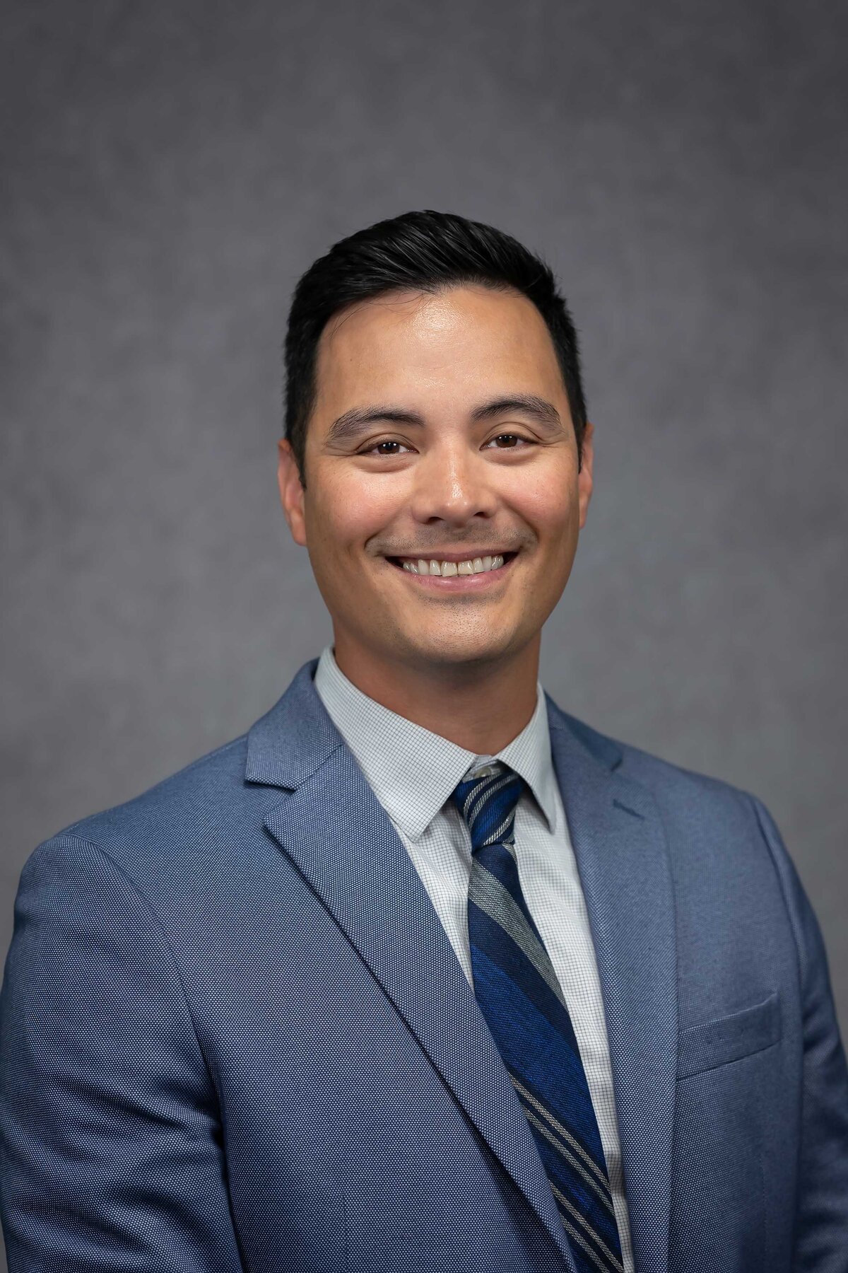 Personal branding headshot for a professional CV featuring a man against a grey background, from the Headshot Gallery Portfolio by Sophie K. Hunter in Dallas